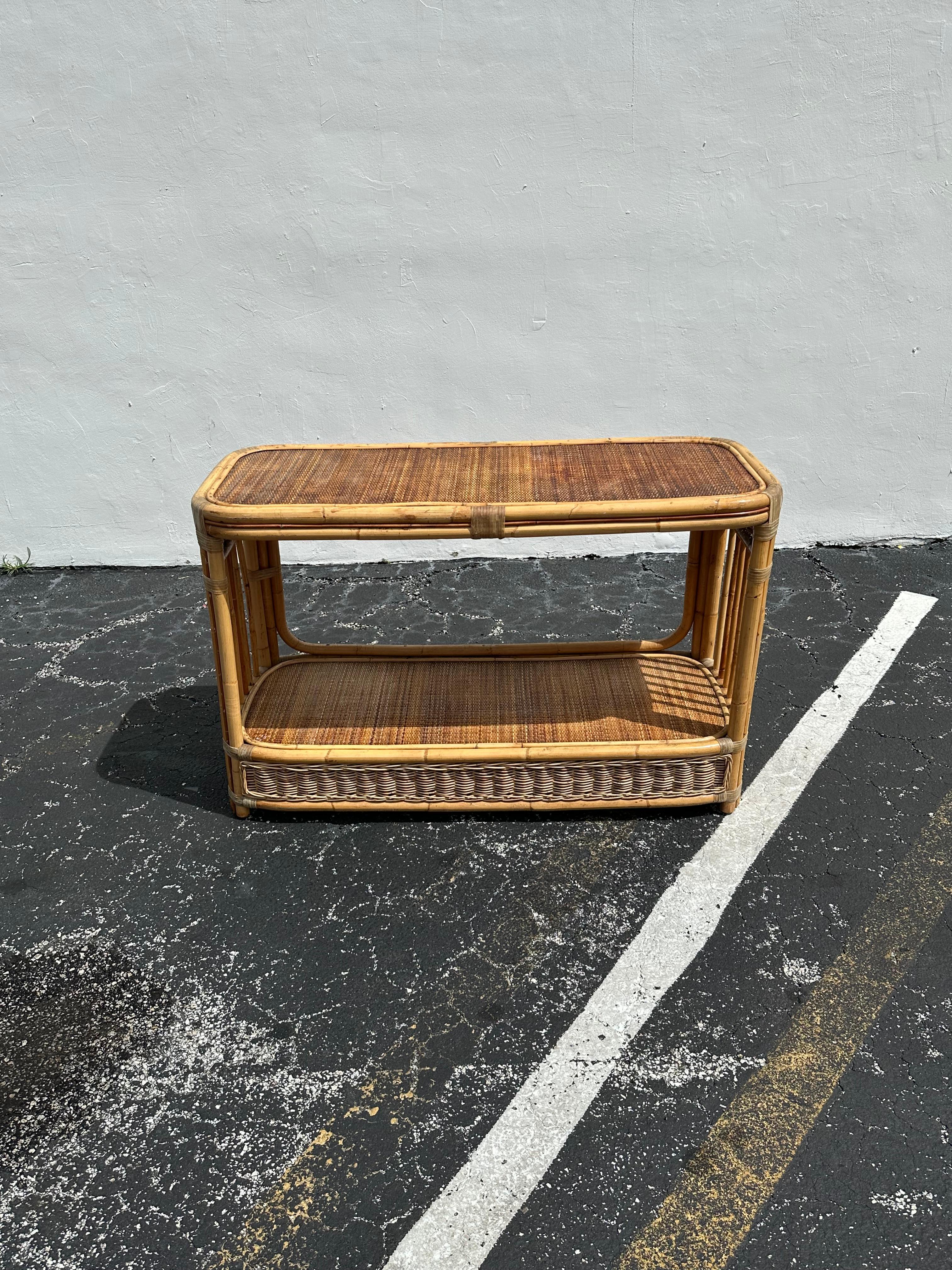 On offer on this occasion is one of the most stunning and rare, rattan and caned design double tier console table you could hope to find. In original and unfinished condition. Outstanding design is exhibited throughout. The beautiful console is