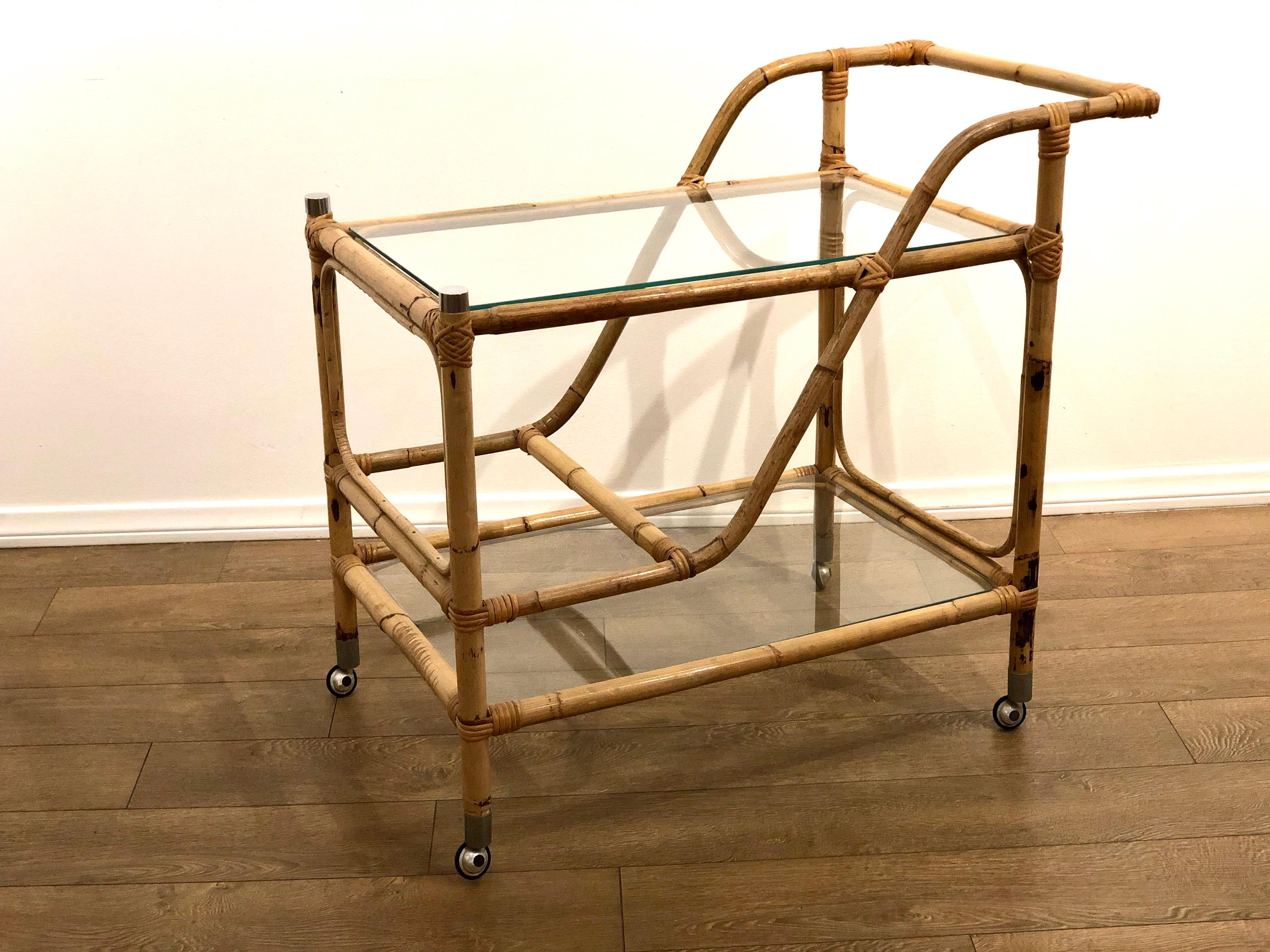 Beautiful, elegant, and hard to find rattan and glass shelves tea cart, with chrome caps and nice elegant casters circa 1970s, nice original condition.