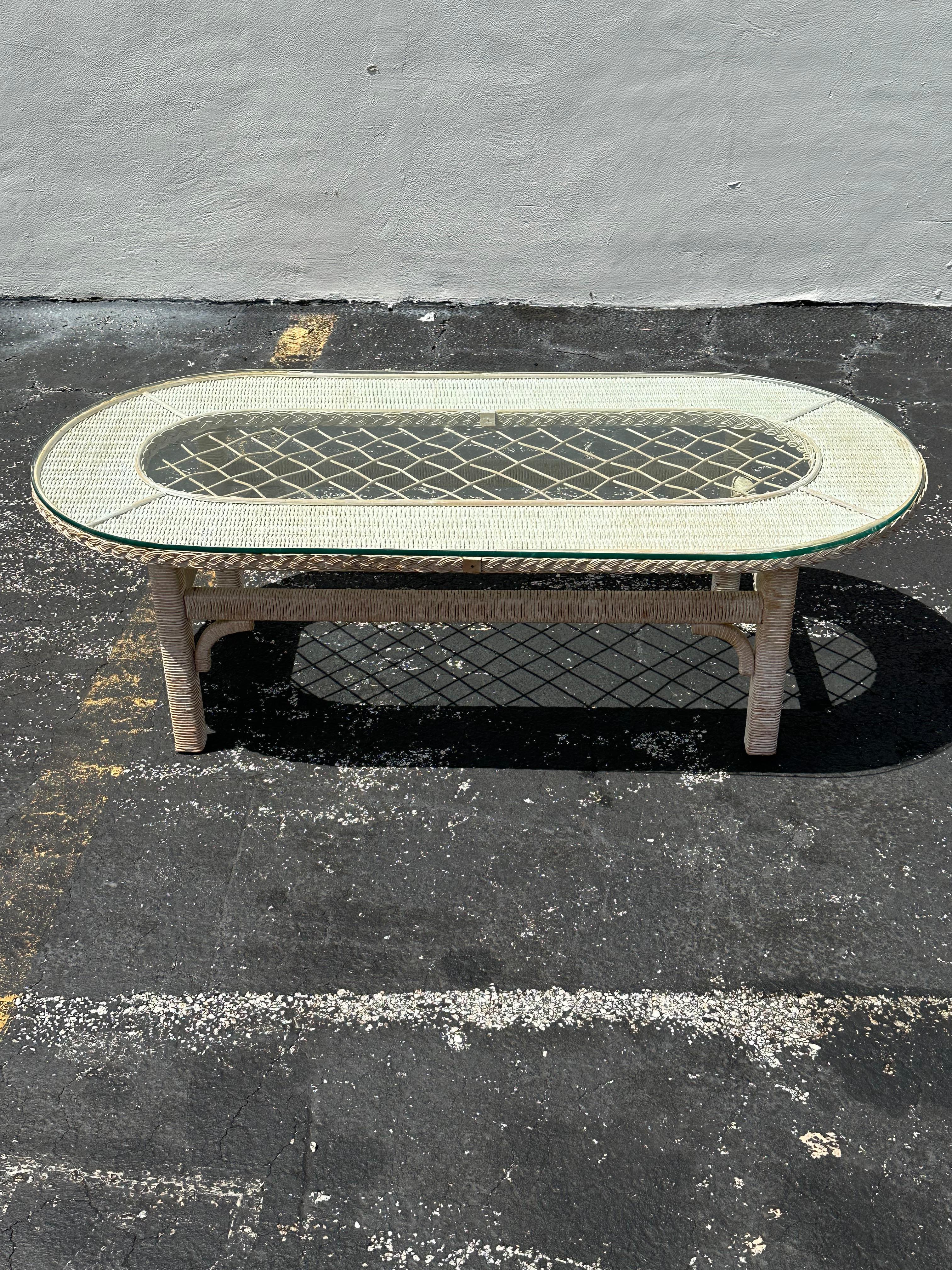On offer on this occasion is one of the most stunning and rare, oval rattan and glass coffee table you could hope to find. In original and unfinished condition. Outstanding design is exhibited throughout. The beautiful table is statement piece and