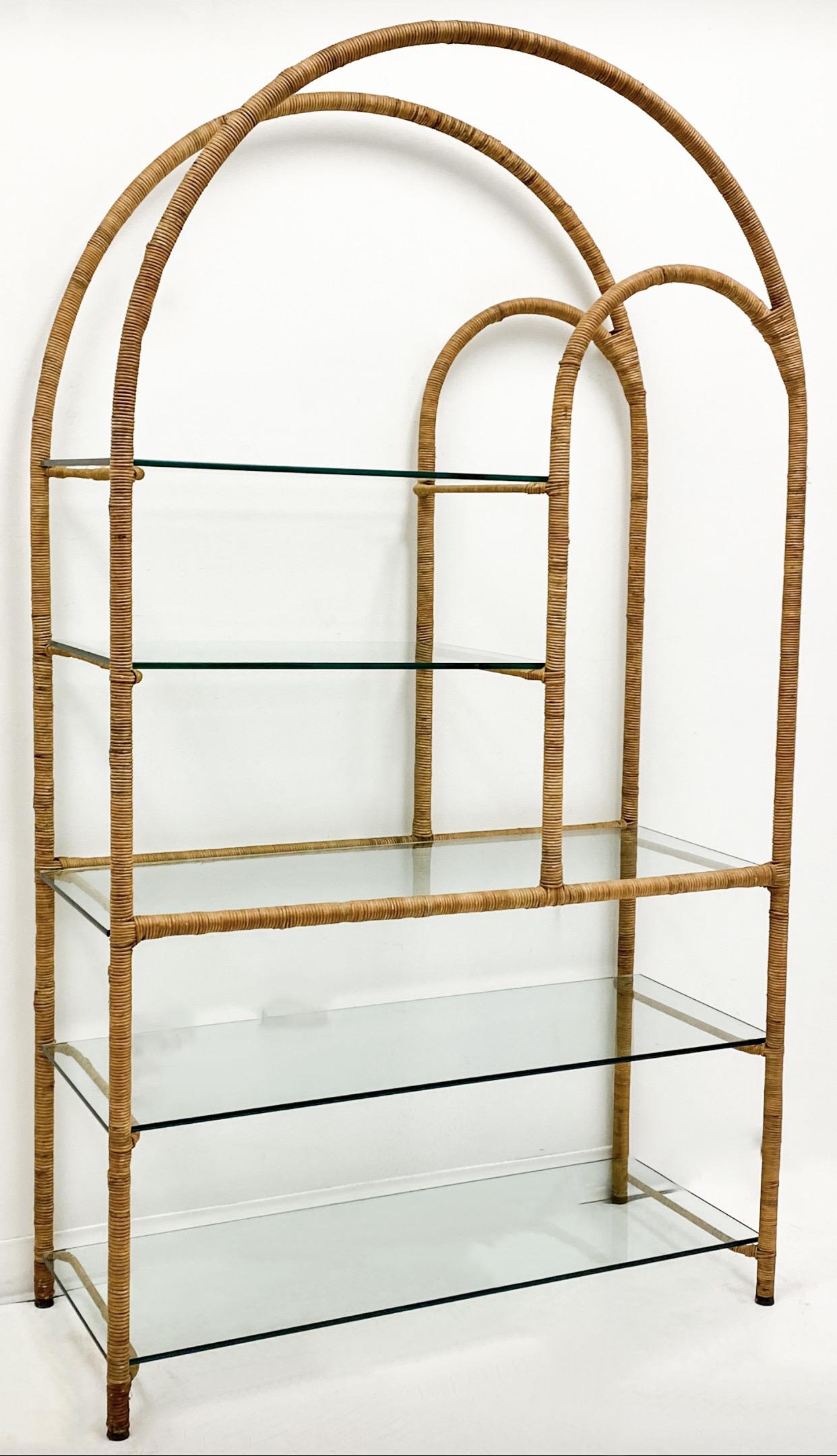 These are 1970s rattan wrapped étagères with glass shelving in very good condition. The metal frames are sturdy and have been meticulously wrapped in bamboo/rattan/wicker. The overall effect is a clean, modern look. They are of unknown manufacture.