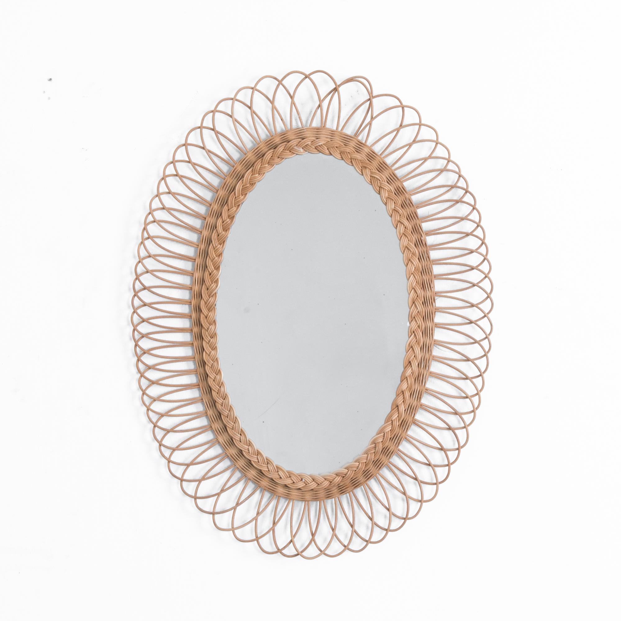 A retro throwback, this French 1970s mirror has a prominent oval shape, rendered in pleasant warm rattan. Surviving the unforgettable epoch of 1970s fashion, this woven beauty is ready to make a splash in a contemporary interior. Adding a great note