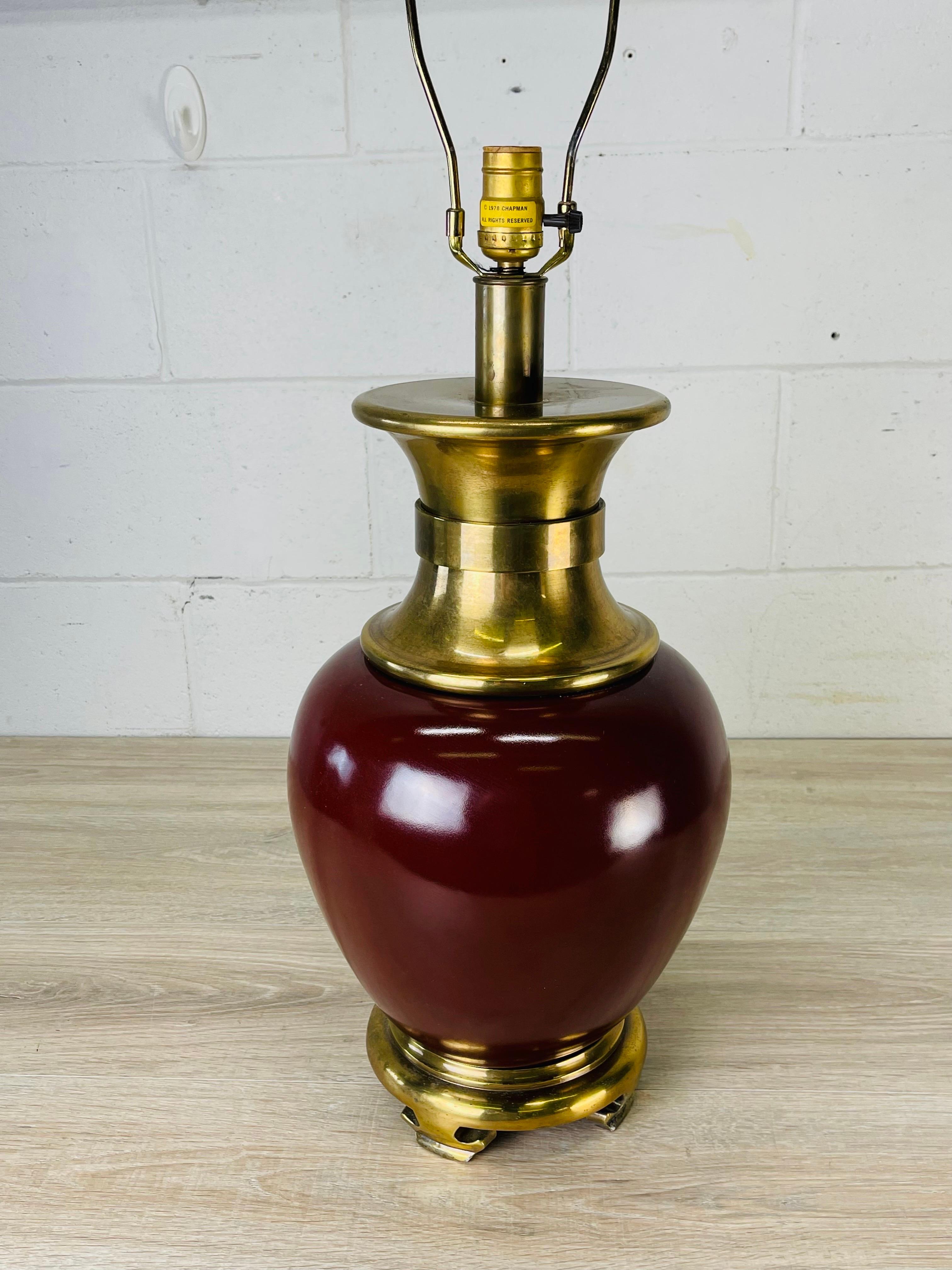 Vintage 1970s red metal and gilt brass base table lamp. The lamp base has an Asian design. Comes with the original finial. Wired for the US and in working condition. Socket, 22”H. Harp, 4”Dia x 8”H. Uses a standard 100W bulb. Marked Chapman.