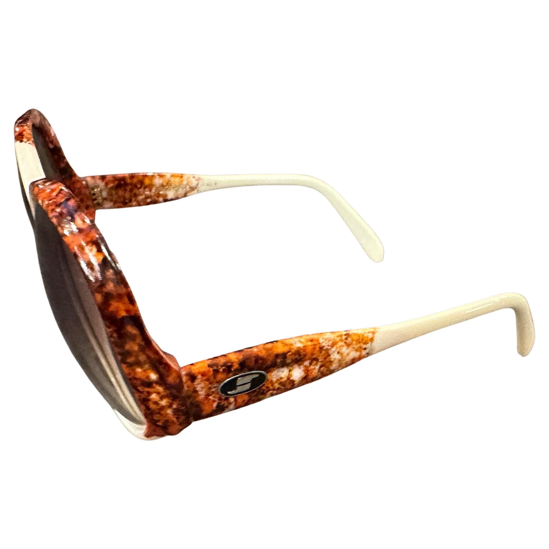 These sunglasses are a quintessential example of 1970s fashion, characterized by their oversized frames, bold color combination, and glamorous, statement-making design. They embody the era's penchant for dramatic accessories and a touch of retro