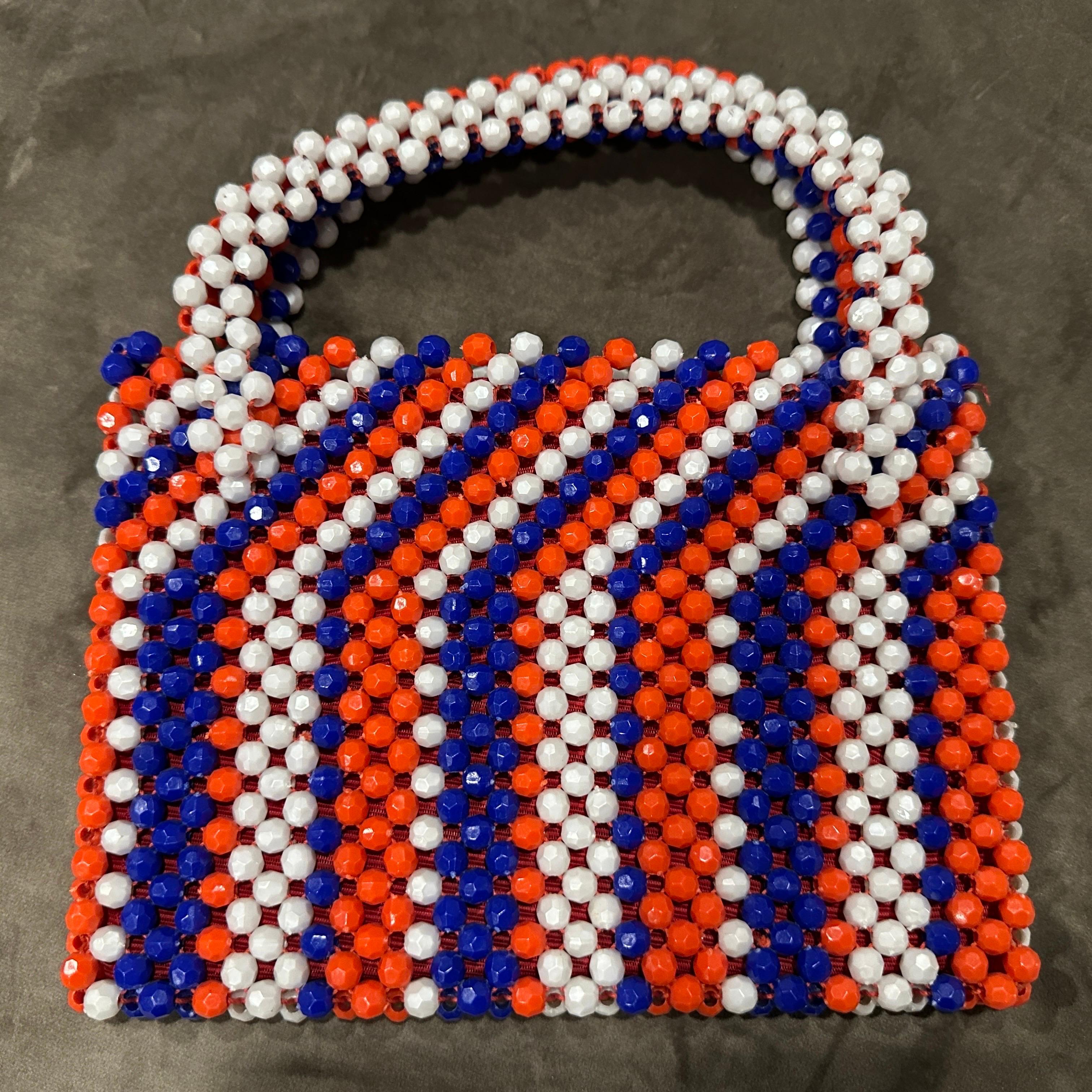 Vibrante bolso italiano de 1970 con cuentas facetadas - Pieza de arte roja, blanca y azul
Retrocede en el tiempo con este llamativo e increíblemente encantador bolso vintage de los años 70, orgullosamente fabricado en Italia. Este accesorio único
