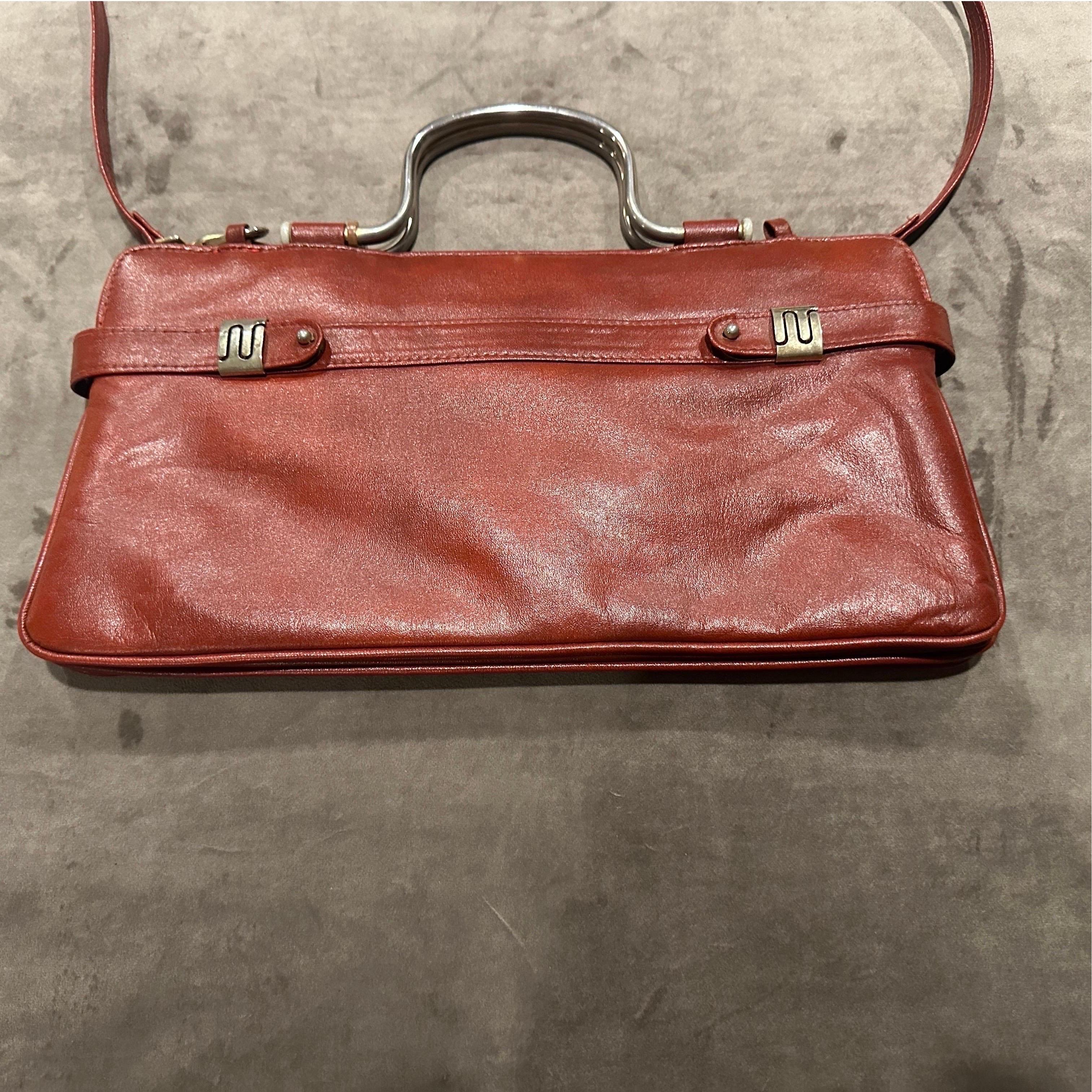 Un sac à bandoulière italien exquis des années 1970, une pièce intemporelle de luxe vintage. Réalisé en cuir rouge souple de haute qualité, ce sac témoigne de l'élégance durable et du savoir-faire artisanal synonymes de design italien.
La silhouette