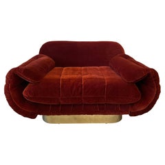 Poltrona rossa degli anni '70 con braccioli curvi e base a zoccolo in ottone