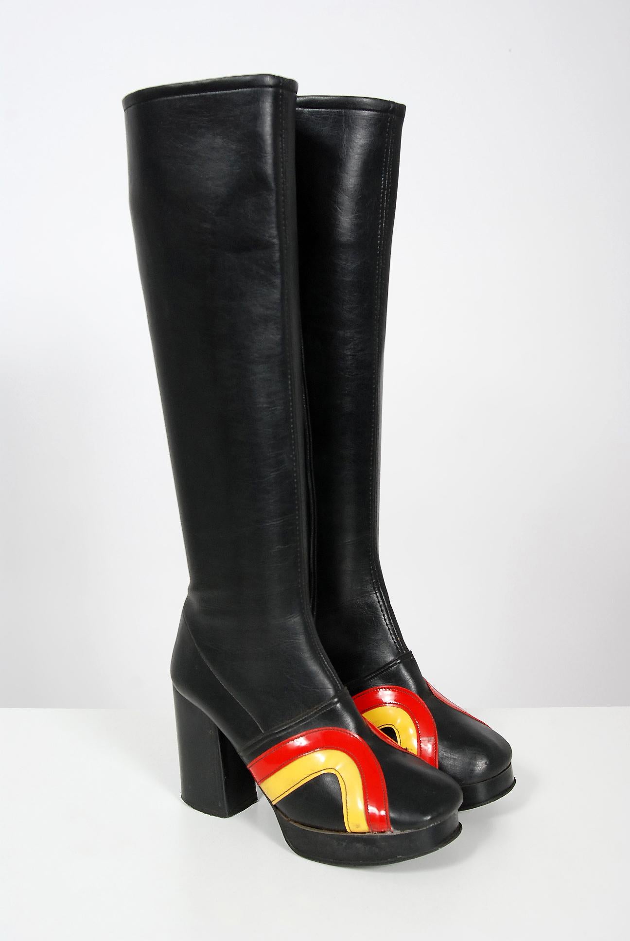 Amazing 1970's British glam rock black leather boots in the most incredible ruby-red and yellow bold vinyl stripe design. These boots have an inch stacked wooden base platform with a high three inch heel. I love the seductive knee-high design. Glam