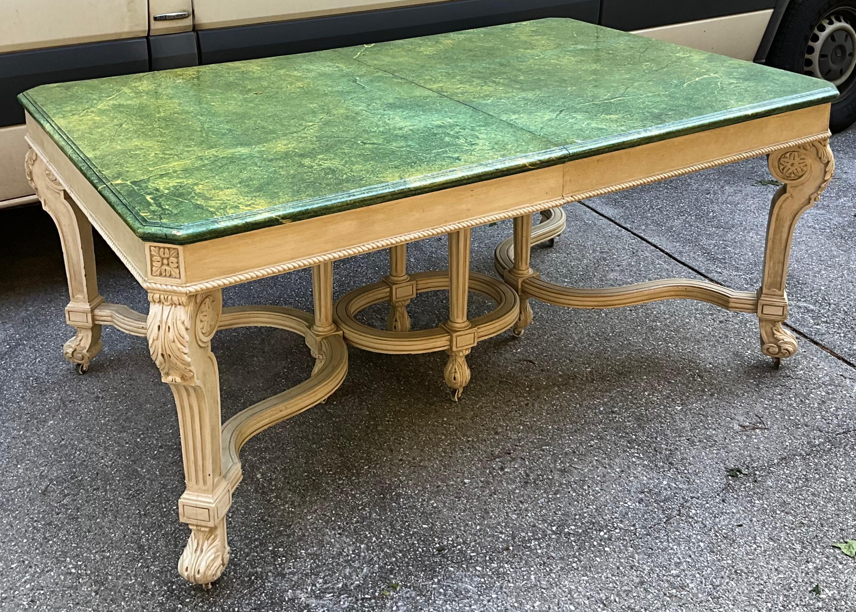 Il s'agit d'une table de salle à manger de style Regency des années 1970, peinte en faux marbre. La finition en faux marbre est d'origine, tout comme la base ivoire. La table a cinq feuilles, et chaque feuille ajoute onze pouces. Il est en très bon