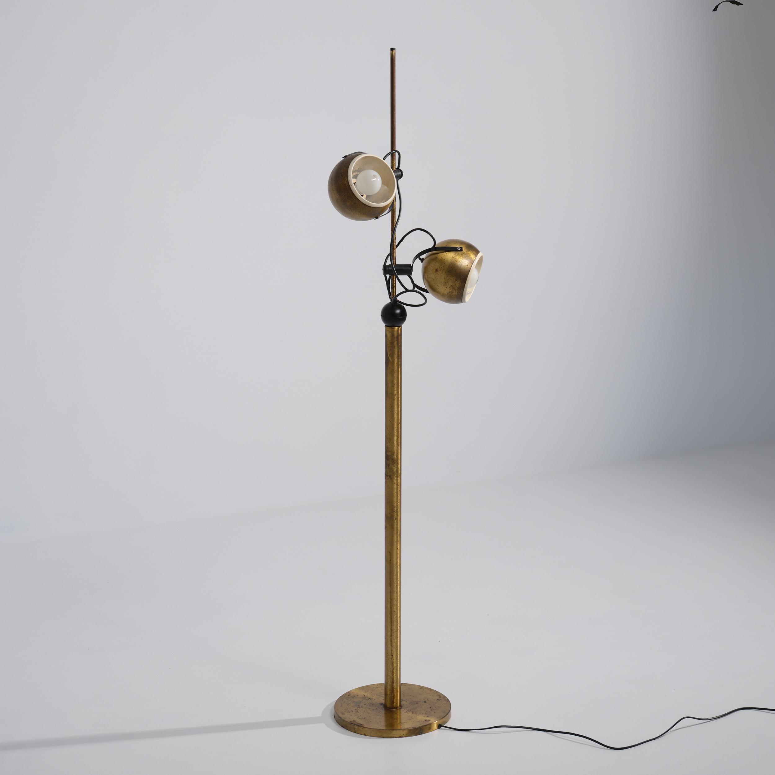 Lampadaire produit par Reggiani dans les années 1970. Une colonne verticale en métal laitonné sur une base circulaire supporte deux têtes lumineuses sphériques montées sur un collier coulissant autour d'une tige centrale. Chaque globe pivote