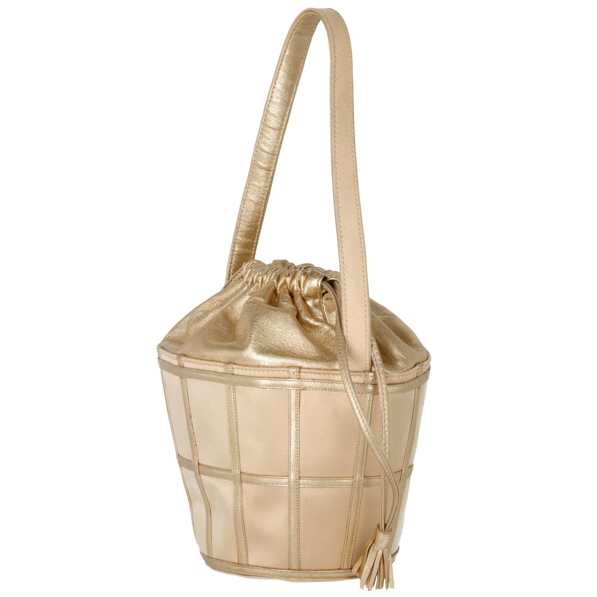 Rene Caovilla gold bucket bag, with decorative leather inserts, short handle, inner bag in soft leather and drawstring closure with two small tassels on the ends. Lined with internal patch pocket.

The item shows slight signs of wear on the skin and