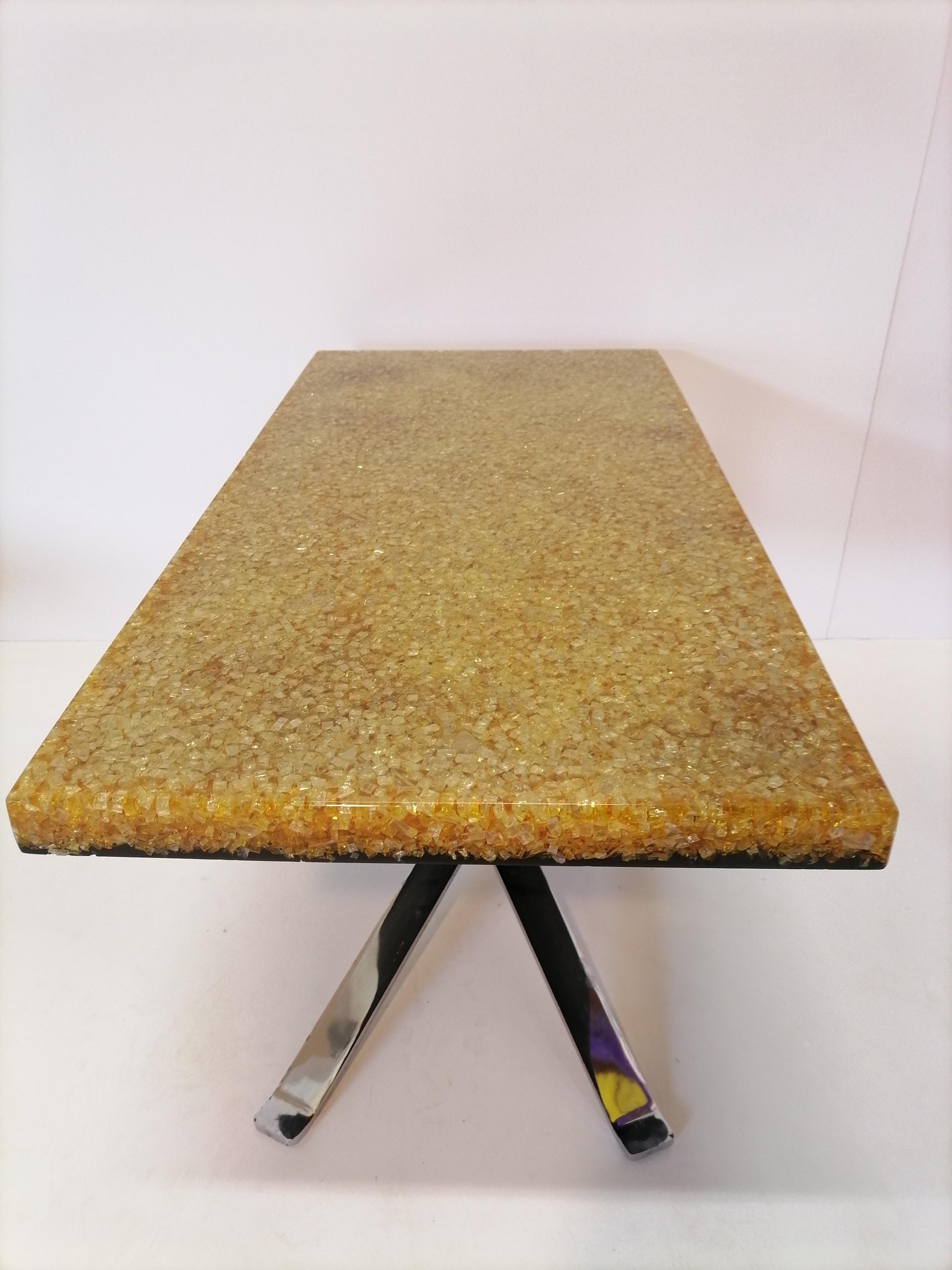 1970s resin coffee table Pierre Giraudon, France

An orange resin and glass break top coffee table by Pierre Giraudon, France, 1970
The table is made from crackled resin with inclusions of broken glass supported by two brass-plated crossed