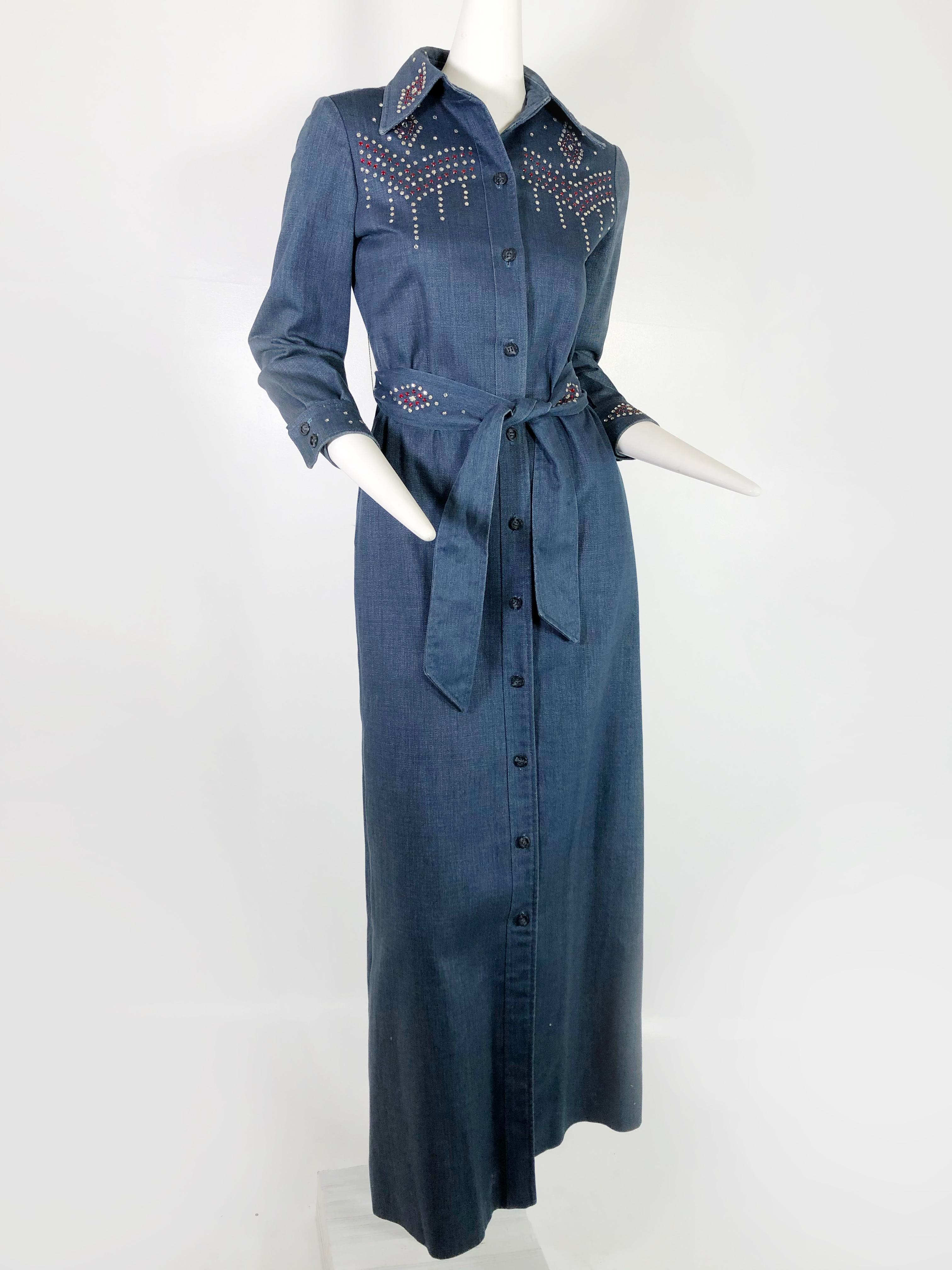 A fabulous Western rock star style denim maxi coat with red and white rhinestone studs. Studded at the neckline, bodice, back, belt and wristbands with classic Western wear patterns. Unlined, with side slit pockets. This is a true vintage