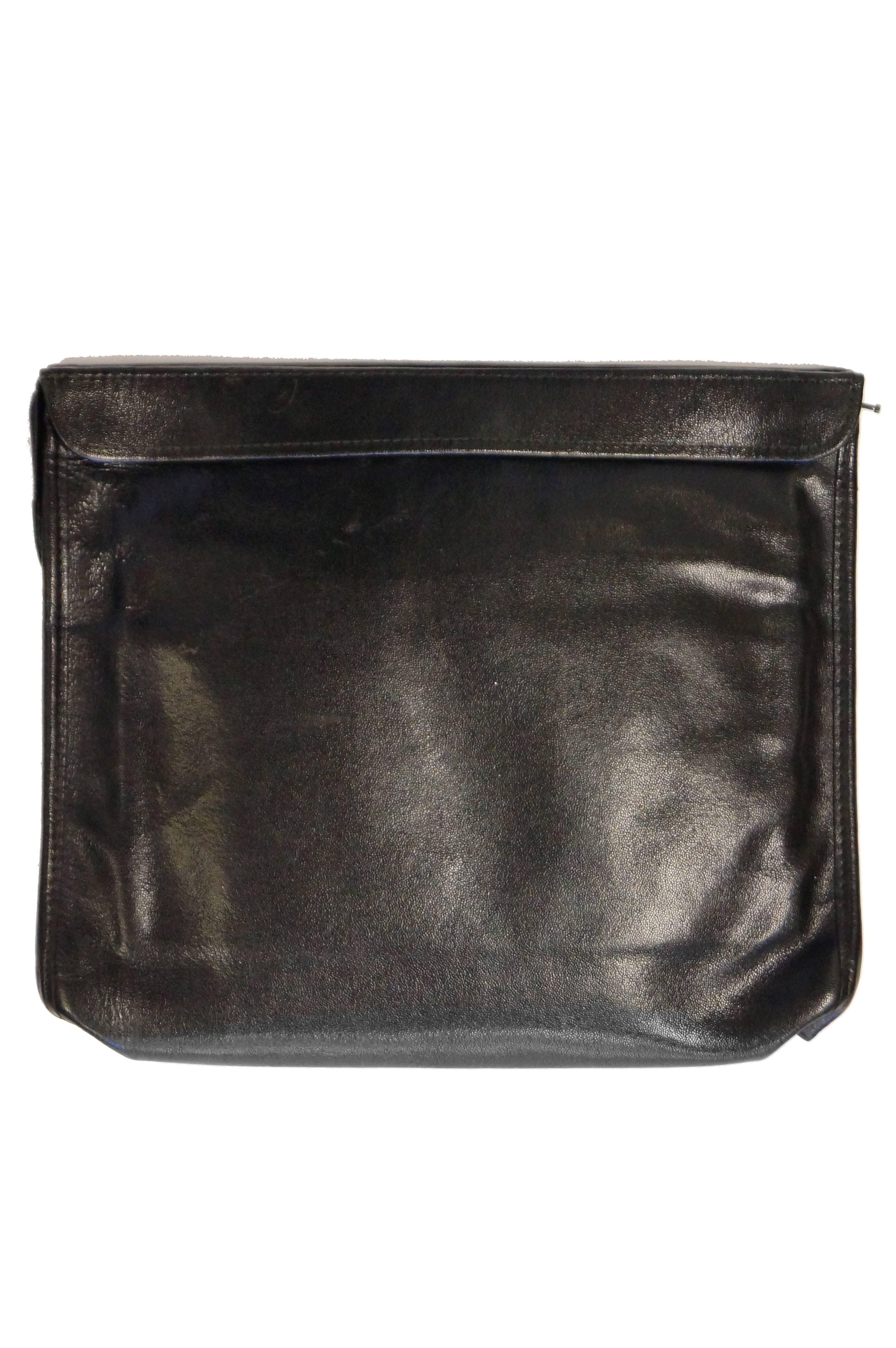 Elegant black folio - style top zipper clutch by Roberta di Camerino. The piece is primarily composed of black pebbled leather, with rounded corners, and a zipper at the top. Features the famous Roberta 