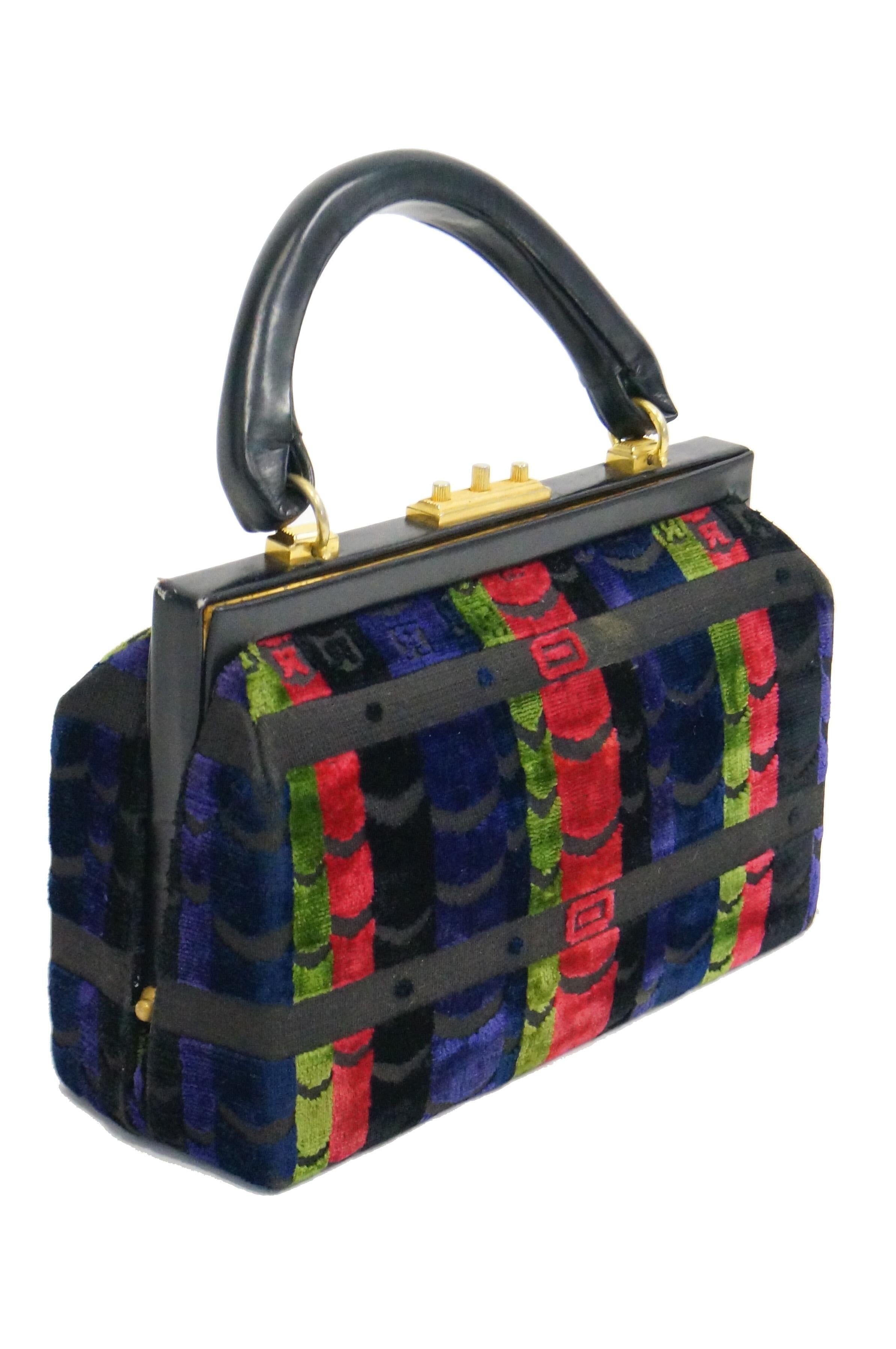This vintage purse by Roberta di Camerino is composed of plush velvet cut in a distinct horizonal belt and buckle pattern of red, green, navy, and black stripes. The famous Roberta di Camerino 