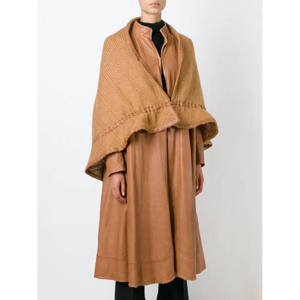 Roberta Di Camerino light brown two-piece suit, consisting of a flared long leather coat with high collar and hook closure, and a knitted cape with leather hems and drawstring.

Size: 42 IT

Flat measurements
Height: 114 cm
Bust: 54 cm
Shoulders: 41