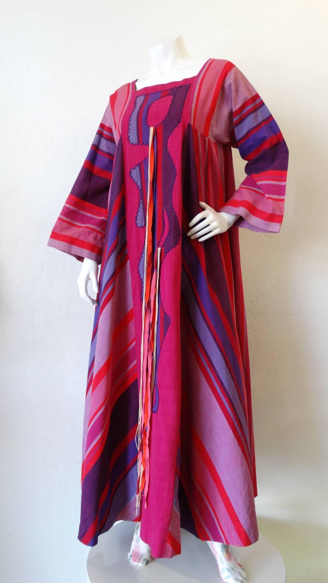 This poolside chic 1970s Roberta Vercellino y Luis kaftan is truly a southwestern gem! Made of a quality woven cotton printed with a multicolored striped pattern, in shades of violet and pink. Abstract shape stitched down the front in a purple