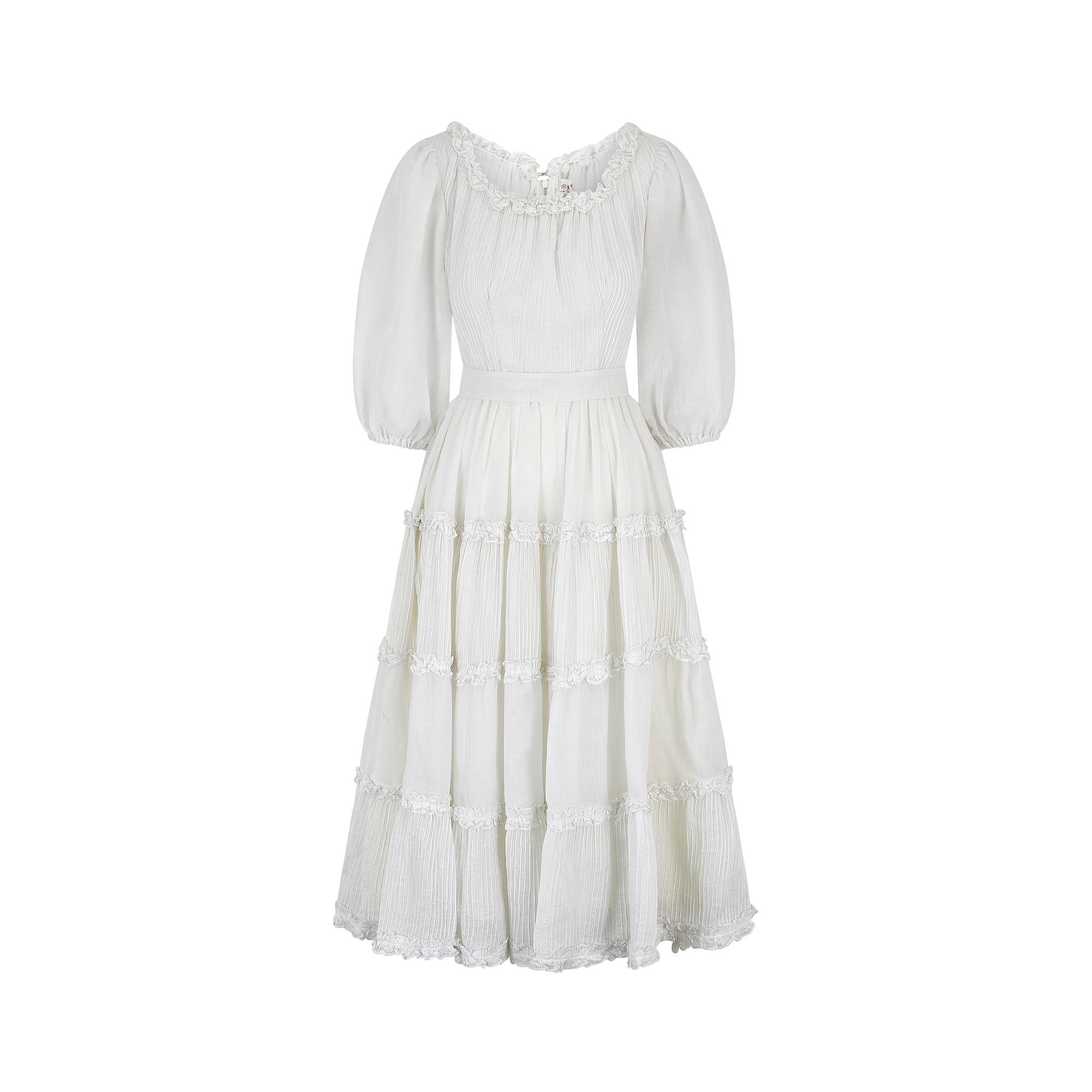 Dieses mexikanische Hochzeitskleid aus weißer Baumwolle im Originalzustand der 1970er Jahre ist in tadellosem Vintage-Zustand und würde mit seiner romantischen, märchenhaften Ästhetik eine bezaubernde Boho-Braut darstellen.  Der mittellange Rock aus