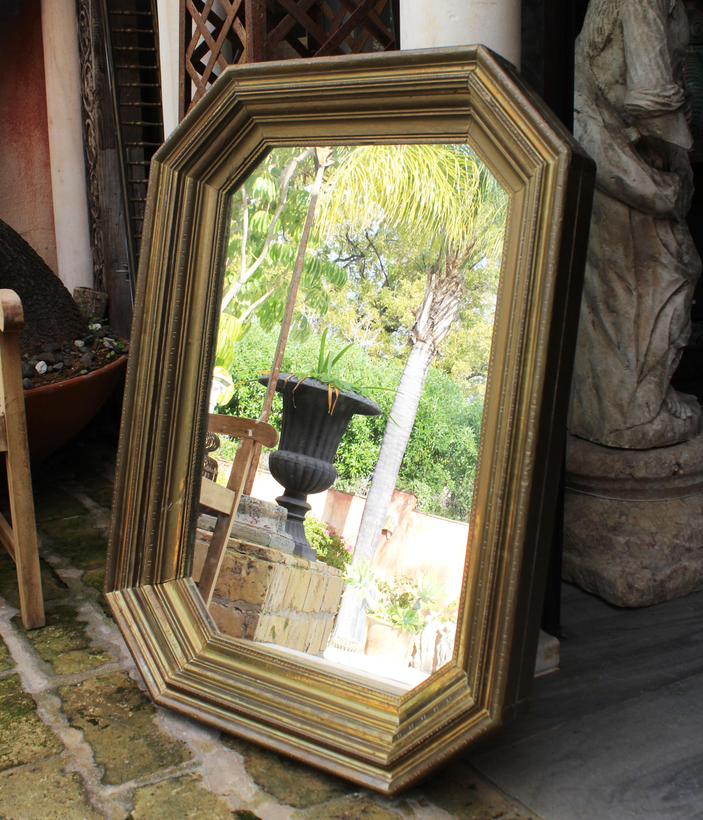 1970s handcrafted gilded brass panels stamped over a wooden frame mirror by Rodolfo Dubarry's workshop in Marbella. 

50 years ago, Argentinian furniture designer Rodolfo Dubarry set up a workshop in Spain and popularized the use of gilded brass