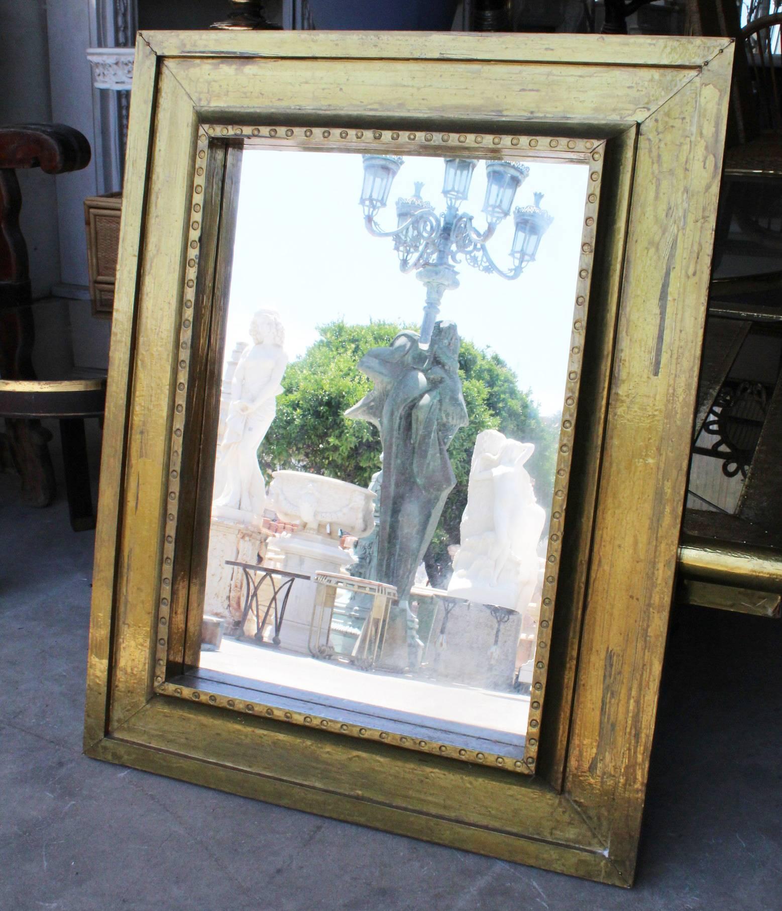 1970s handcrafted gilded brass panels stamped over a wooden frame mirror by Rodolfo Dubarry's workshop in Marbella. 

50 years ago, Argentinian furniture designer Rodolfo Dubarry set up a workshop in Spain and popularised the use of gilded brass