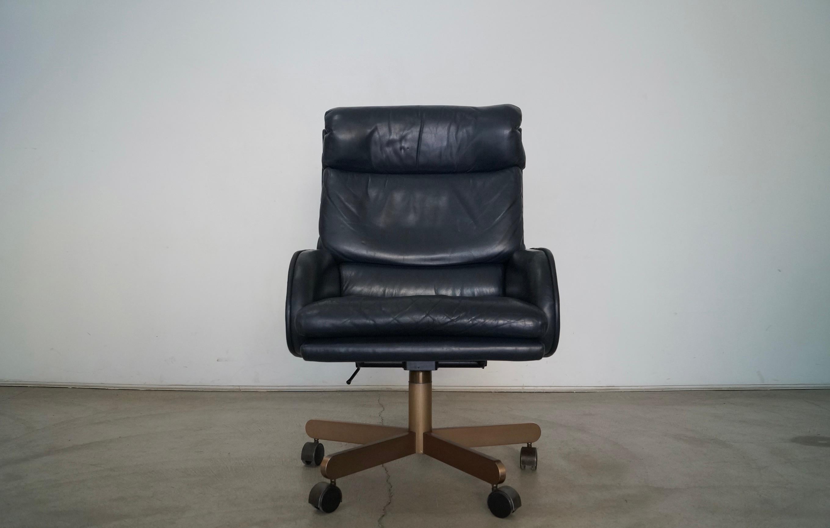 Vintage original Dunbar executive office desk chair for sale. Designed by Roger Sprunger in the 1970's, and manufactured by Dunbar. Has the original seal and label underneath. It has the original dark navy blue leather in great vintage condition.