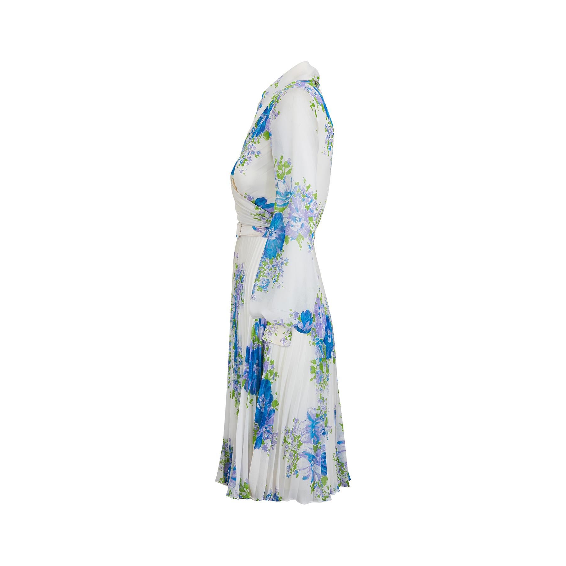 robe à plis en accordéon Marcel Fenez by Roland Klein des années 1970.  Le tissu est une georgette synthétique et présente un joli motif floral de lilas, de bleu français et de feuillage vert citron sur fond blanc. Le corsage est de type cache-cœur