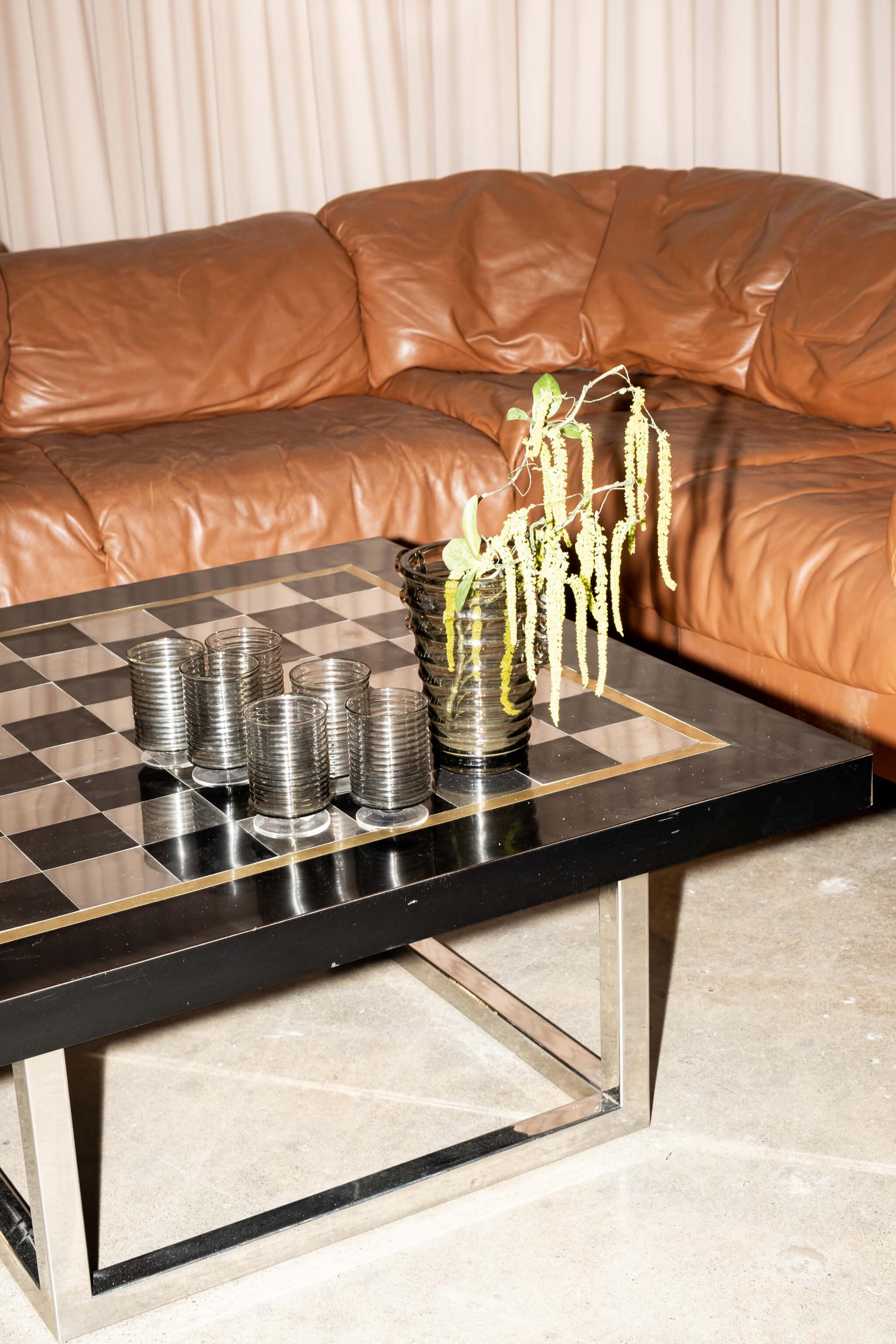 La table basse italienne des années 1970 de Romeo présente un plateau en échiquier noir et chromé avec une bordure dorée qui repose proprement sur sa base chromée. La sensibilité glamour de la Rega, très présente dans ce design, est communément