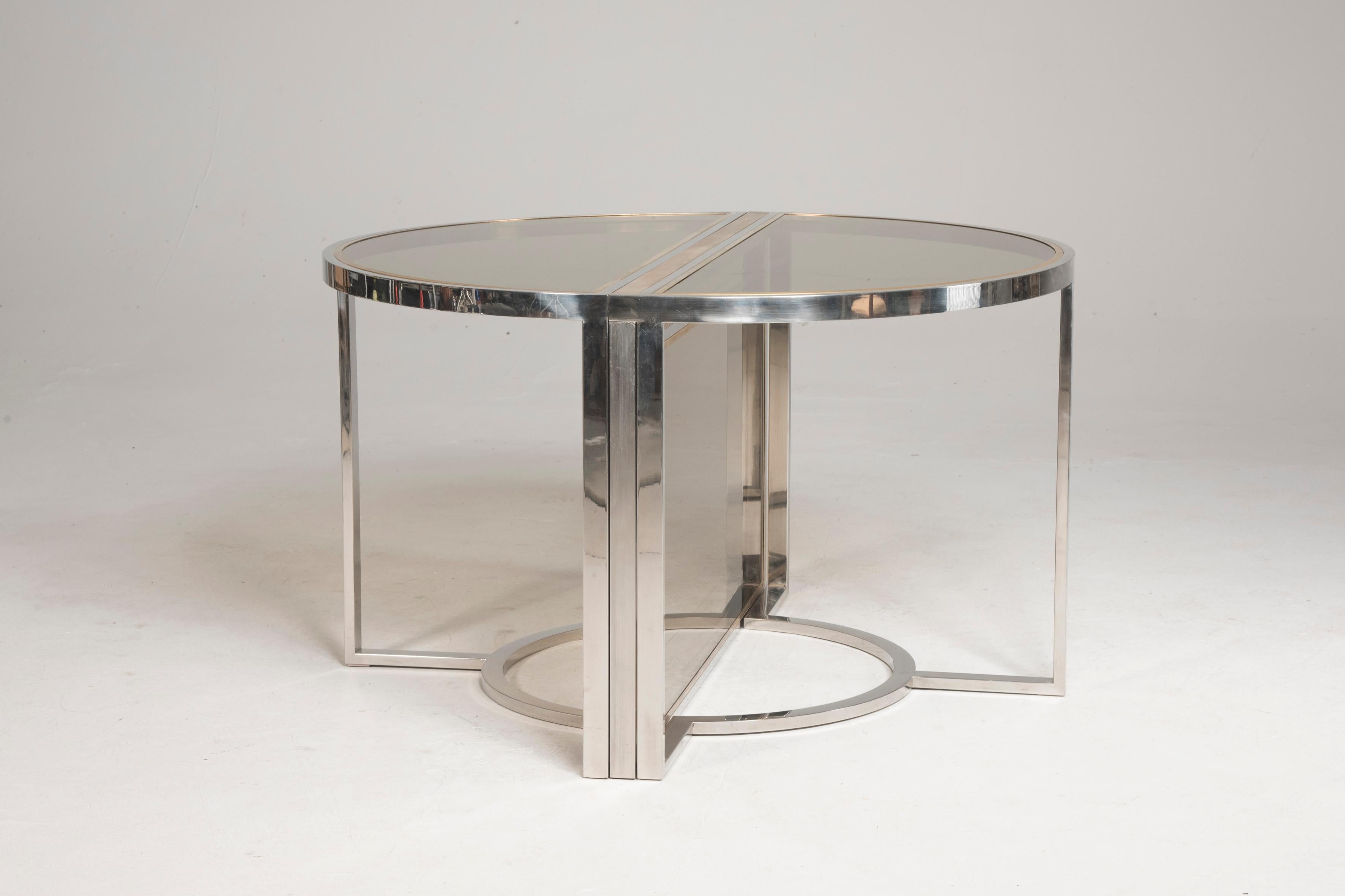 1970s Romeo Rega chromed and brass smoked glass rounded extendable table.

This is a very particular table: You have four solutions in one! rounded table, oval table, two table consoles. It is a rounded extendable table composed by two half moon
