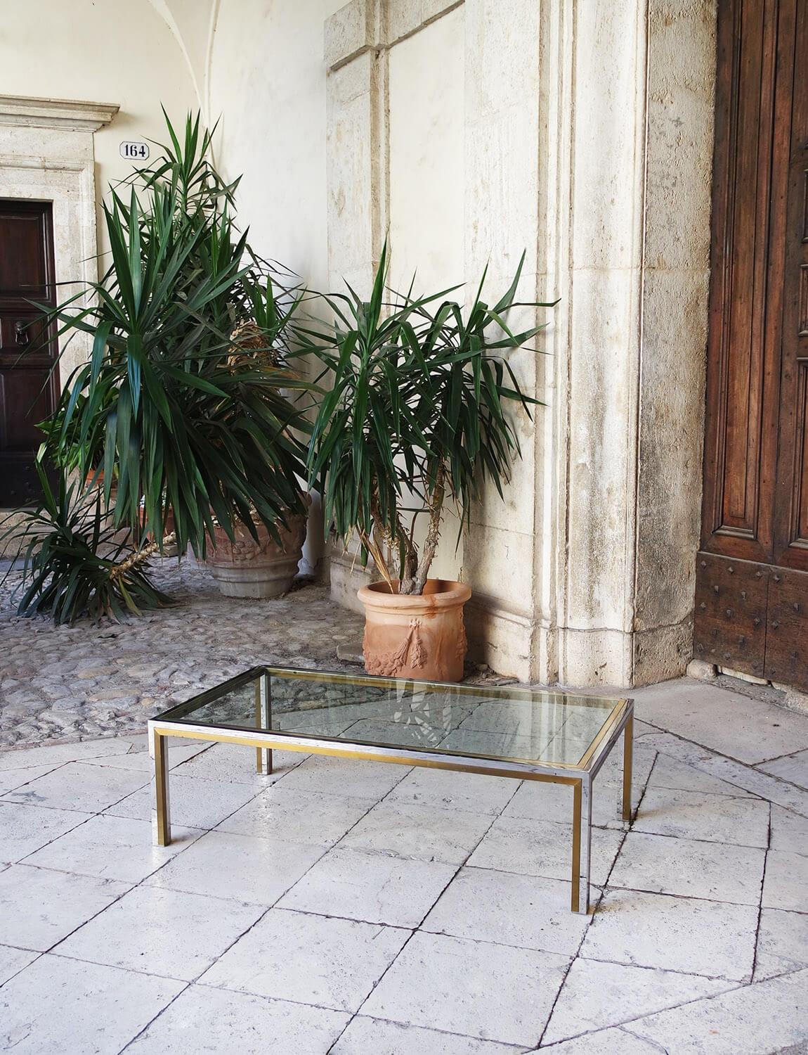 Magnifique table basse à plateau en verre et incrustation de chrome et de laiton de Romeo, datant des années 1970. Cette pièce est en bon état. 