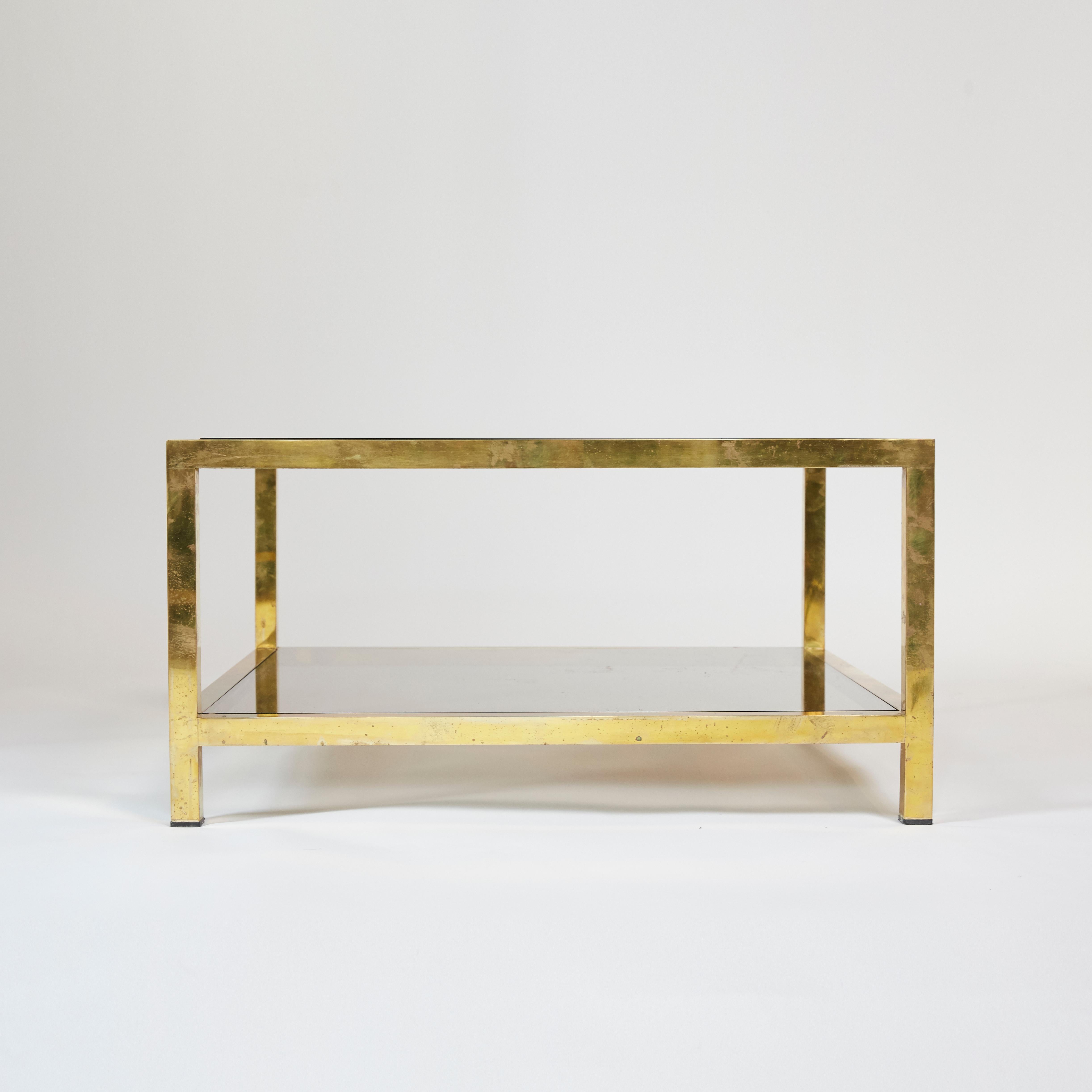 A pair of 1970s Italian coffee tables in brass and smoked glass designed by Romeo Rega. Brass and glass show some marks consistent with age and use.

Measures: W 80 cm x D 80 cm x H 41 cm 
W 31.5 in x D 31.5 in x H 16.14 in.