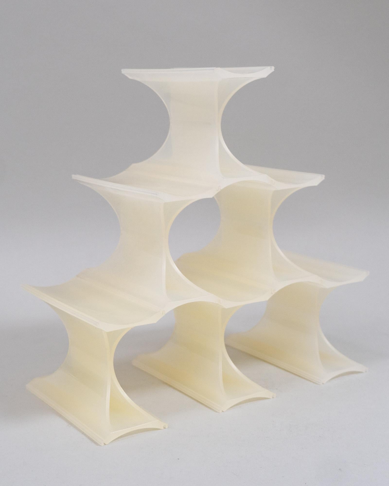 Stock des années 1970 du porte-bouteilles Infinity de Ron Arad pour Kartell. Peut être assemblé en plusieurs configurations. 

Extrait de la description du site web de Kartell :
Infinity est un porte-bouteille modulaire, coloré et curviligne. Les