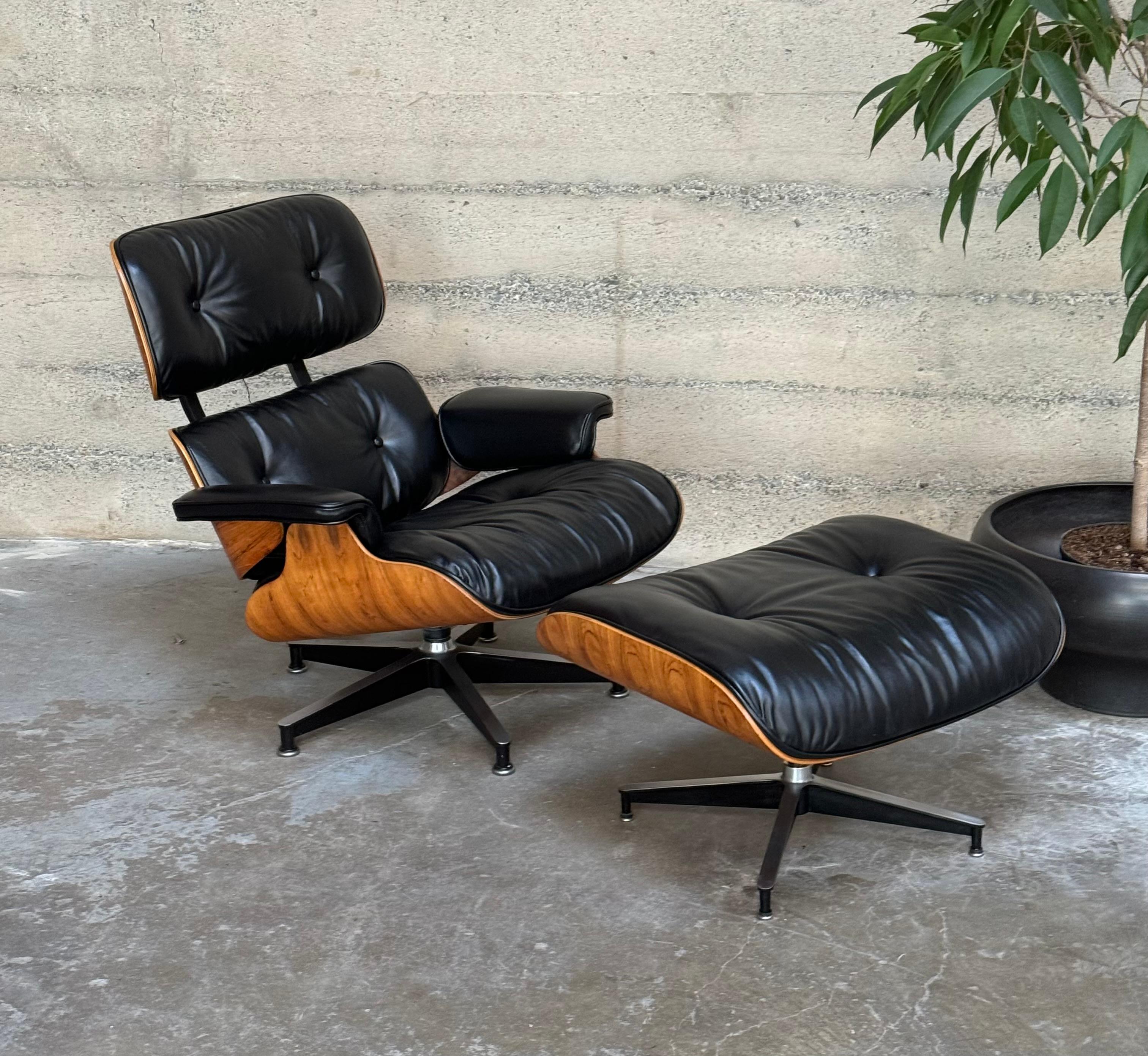 Eames lounge and ottoman with rosewood shells and upholstered in premium black leather from Austria. The rosewood is a lighter shade in the blonde range with figurative black graining to the wood. The chair has undergone a complete restoration with