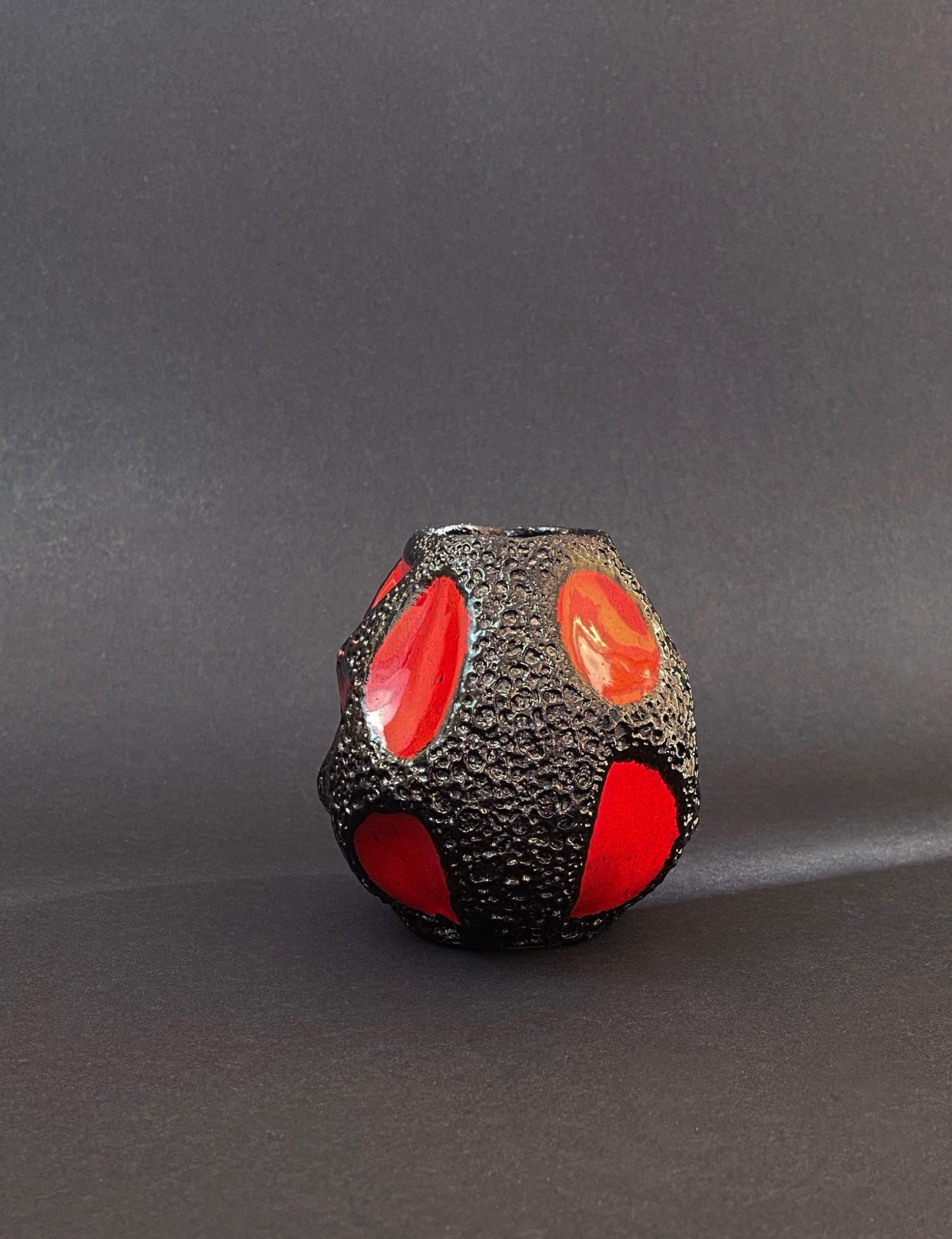 Design highlight in red and fat lava glase black by acclaimed ceramic maker Roth, Germany.
Created and made in the 70s, these are still and again highly sought after collectors pieces.

This very one is standing out in its spherical shape with the
