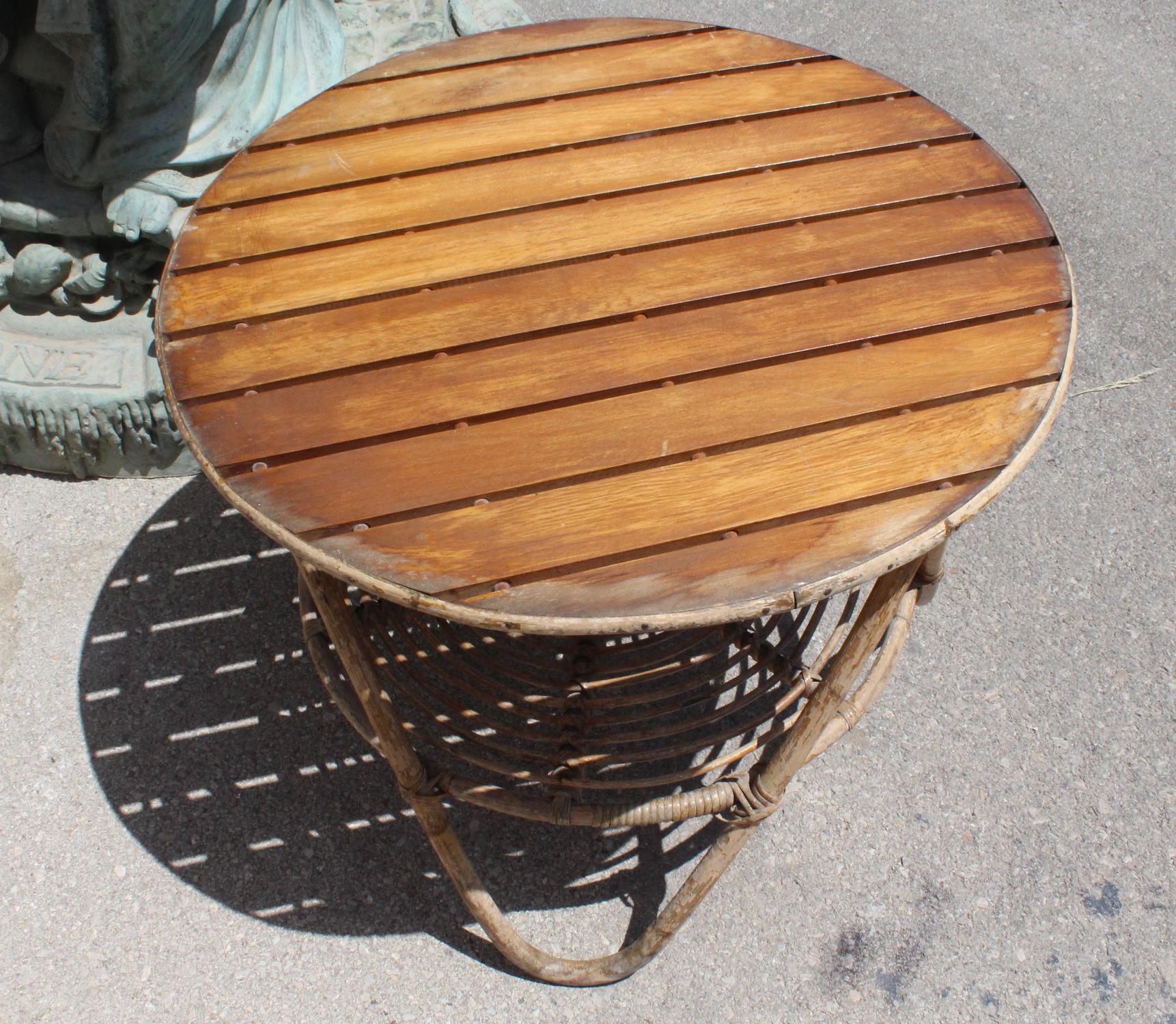 1970s round Spanish side table with bamboo feet, a low shelf and top with elongated wooden boards.