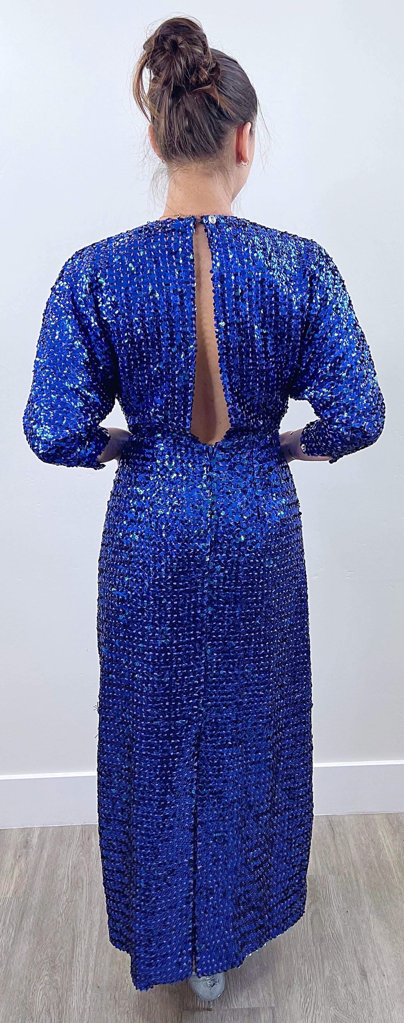 Beautiful 1970s royal blue fully sequined gown ! Features thousands of hand-sewn sequins throughout. Peek-a-boo back with hidden zipper and hook-and-eye closures. Rhinestone buttons at each sleeve cuff. Dolman sleeves can accommodate an array of
