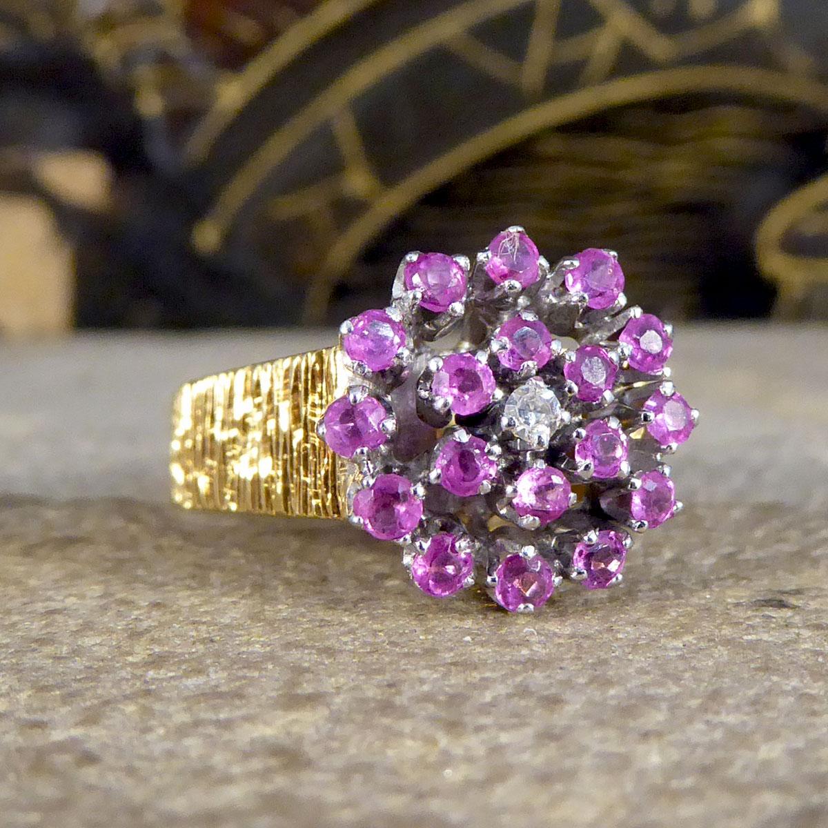 Such a gorgeous classic 1970's designed ring with a bark effect detail around the 18ct Yellow Gold band. The centre of the ring is a small Diamond with two rows of Rubies to cluster in making a flower shape all set in 18ct White Gold. The whole ring