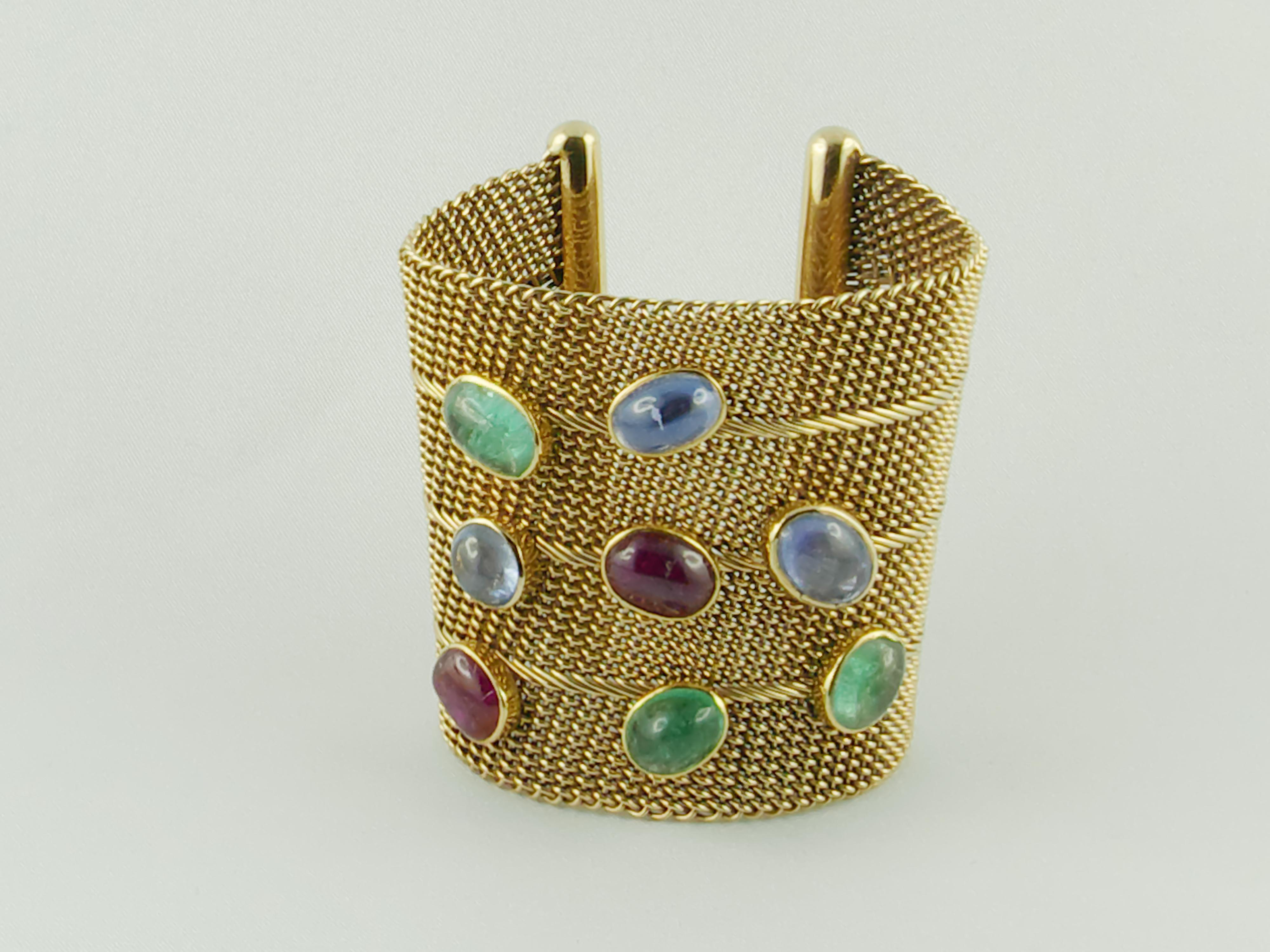 Attractive and unconventional 1970s Mesh Net Wrist Armlet 14 Karat Yellow Gold with two Ruby three Emerald and three Sapphire Cabochons.
This eye-catching dramatic color contrast Bracelet is an elegant and casually sophisticated piece that fits a