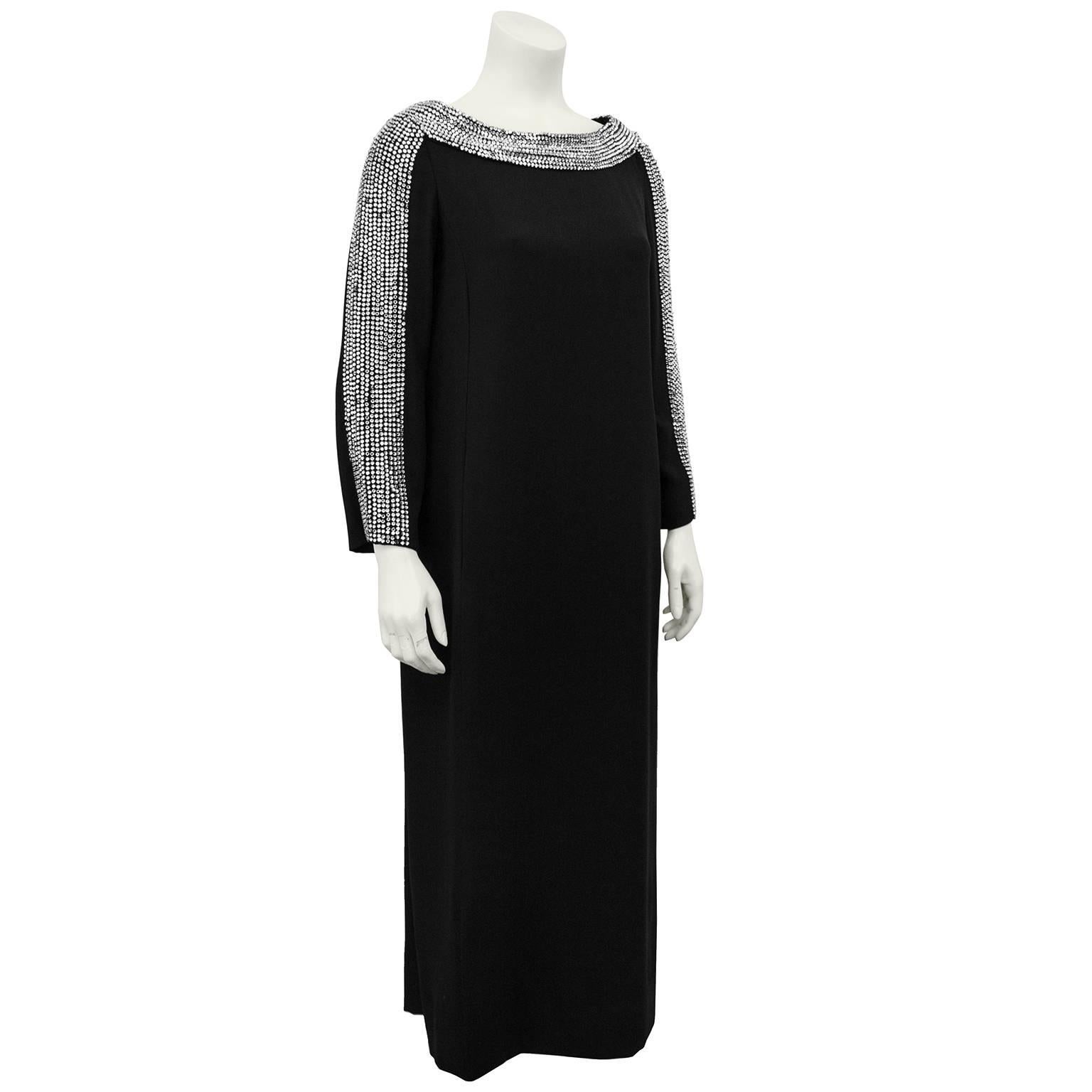 Gorgeous 1970s Ruth McCulloch tea length black crepe evening dress embellished with a thick trim of large rhinestones along the neckline, and down the sleeves. Simple long shift shape with hidden slit pockets and two small slits. Hidden zipper at