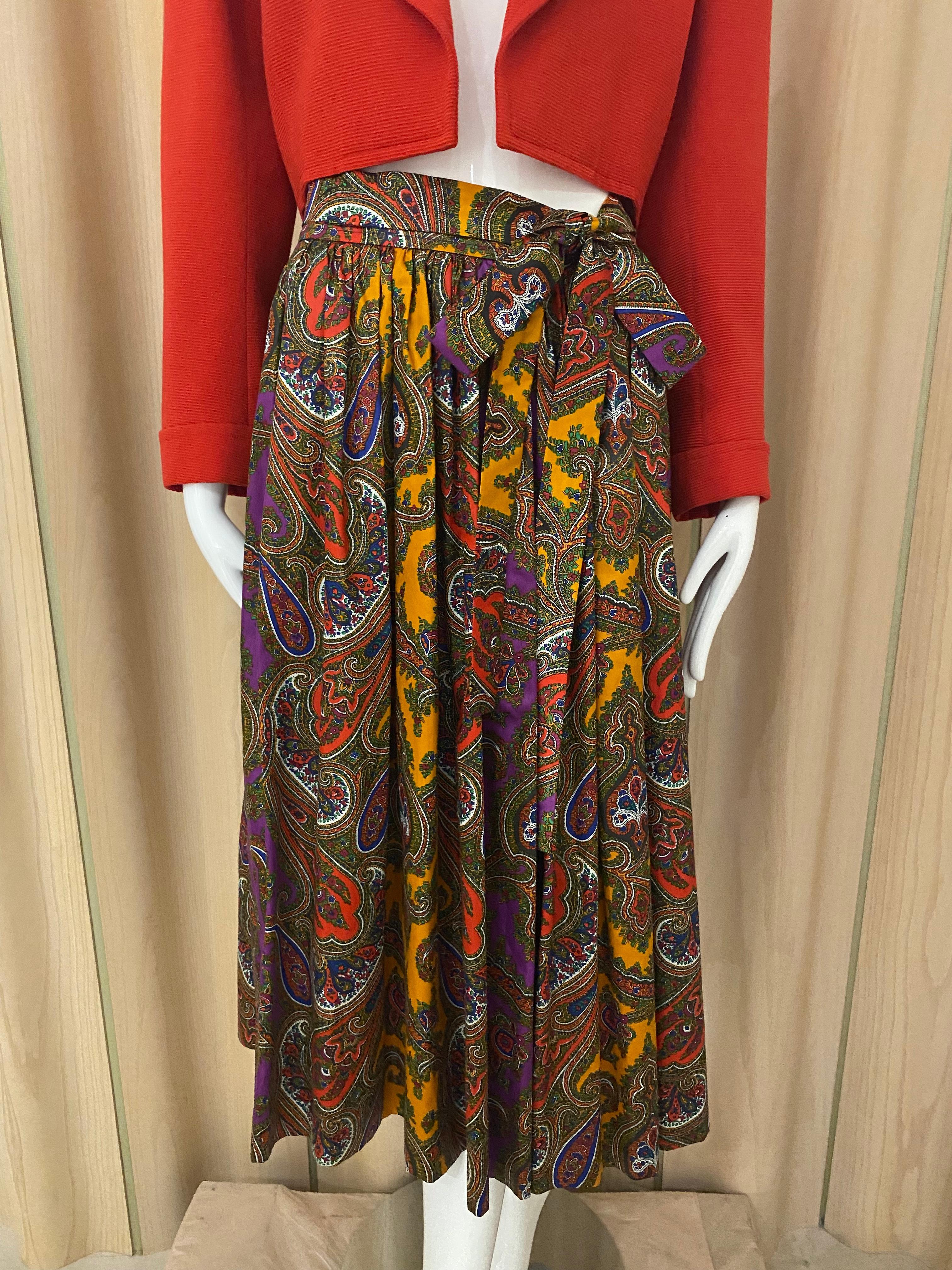 Beautiful 70s Saint Laurent Rive Gauche Cotton Paisley Print in Purple, orange, Yellow, white and green.  Skirt comes with cotton belt.
Waist: 28”