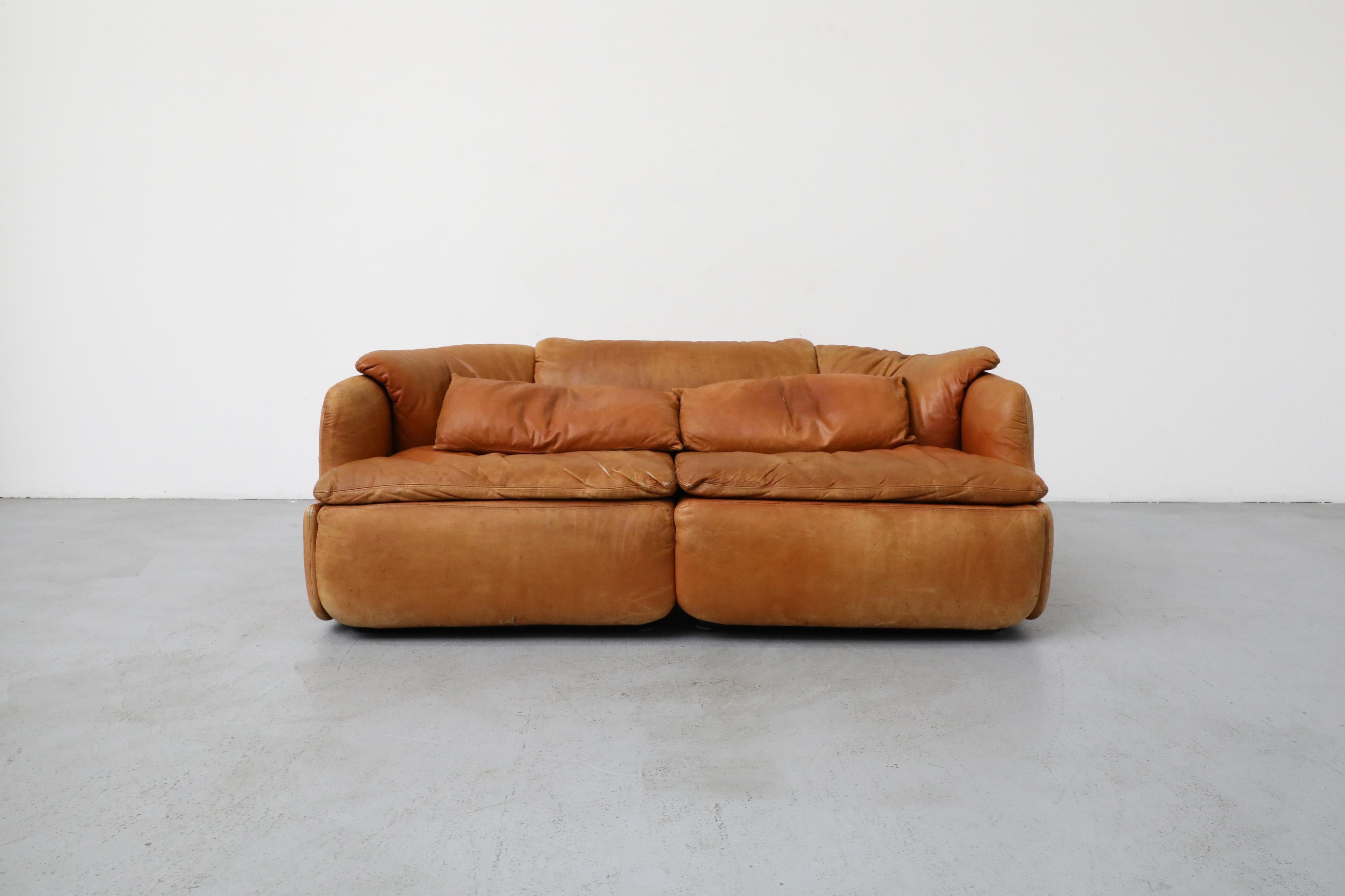 Saporiti 'Confidential' cognac leather loveseat by Alberto Rosselli. This luxury 2 seater with polyurethane injected foam cushions brings timeless design to any space. Designed in 1972, the Confidential Collection is one of the most important