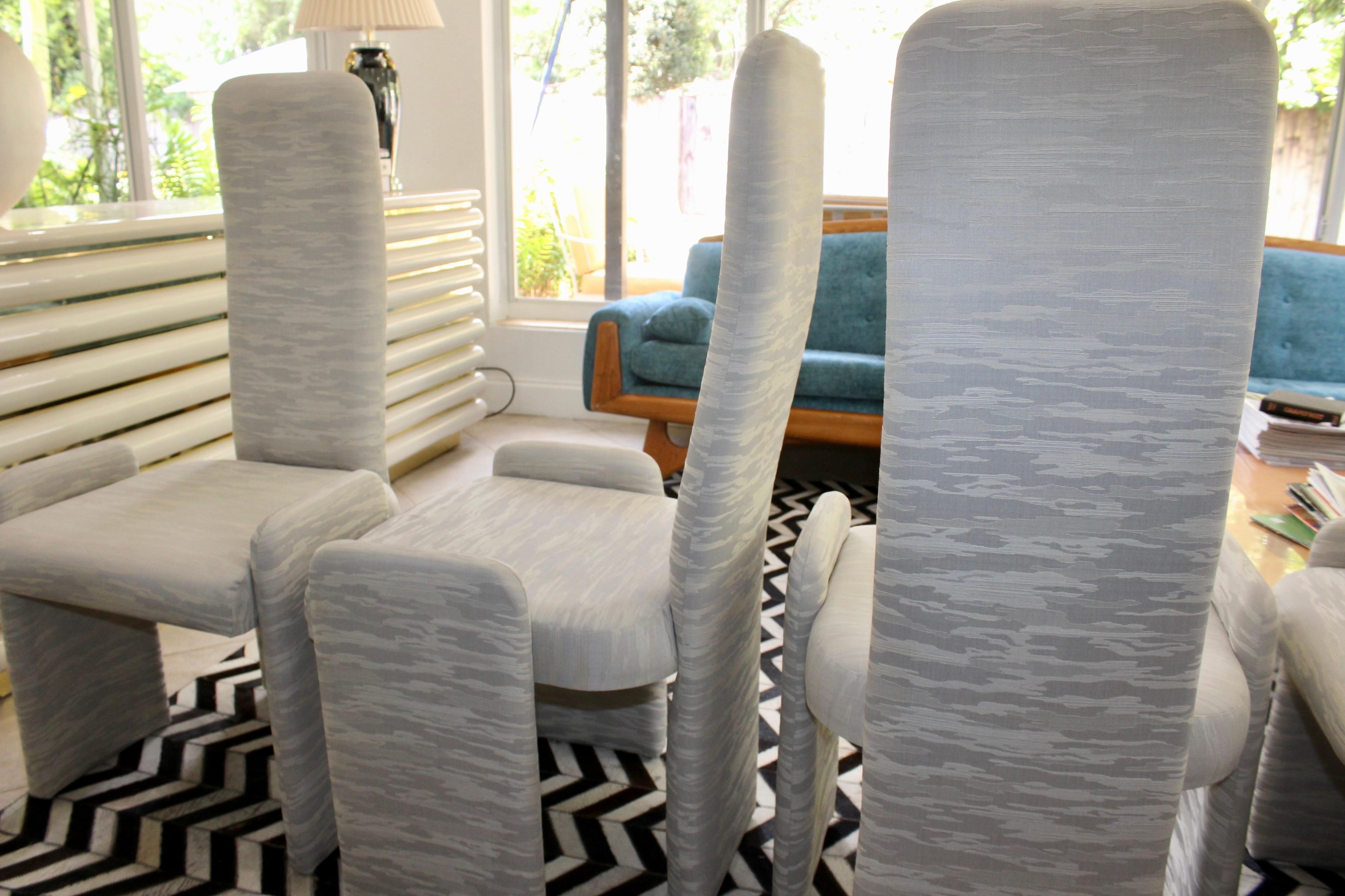 This set of four Italian dining chairs has a modernist sensibility that is interesting to view from all angles. Recently reupholstered and restored in modern white and gray striped fabric upholstery by precision furniture inc. Perfect for a