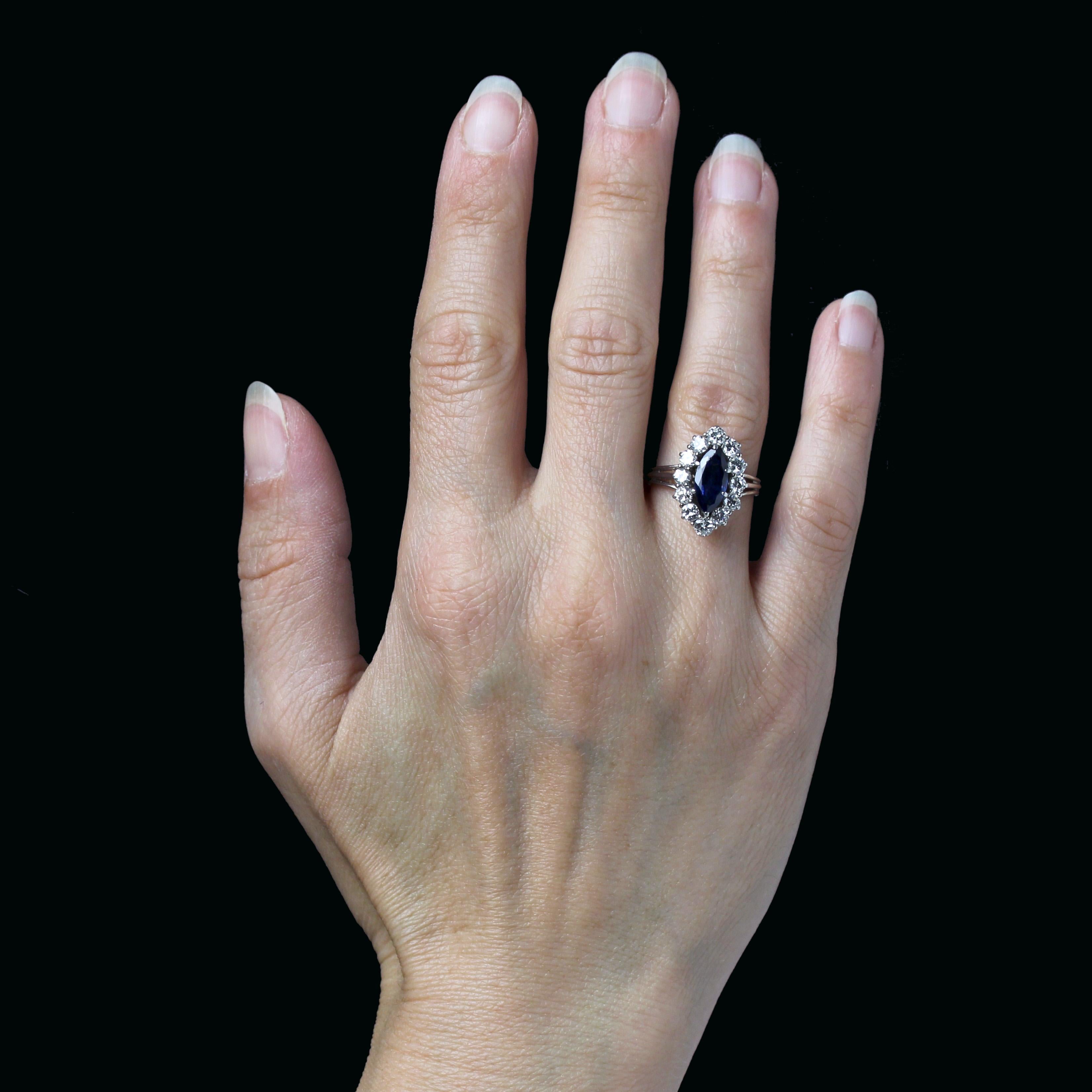 Anillo de oro blanco de 18 quilates.
Elegante anillo marquesa vintage con cesta y banda de alambre dorado. El motivo marquesa presenta un zafiro central talla navette sujeto por garras y rodeado de diamantes talla brillante de estilo antiguo.
Peso