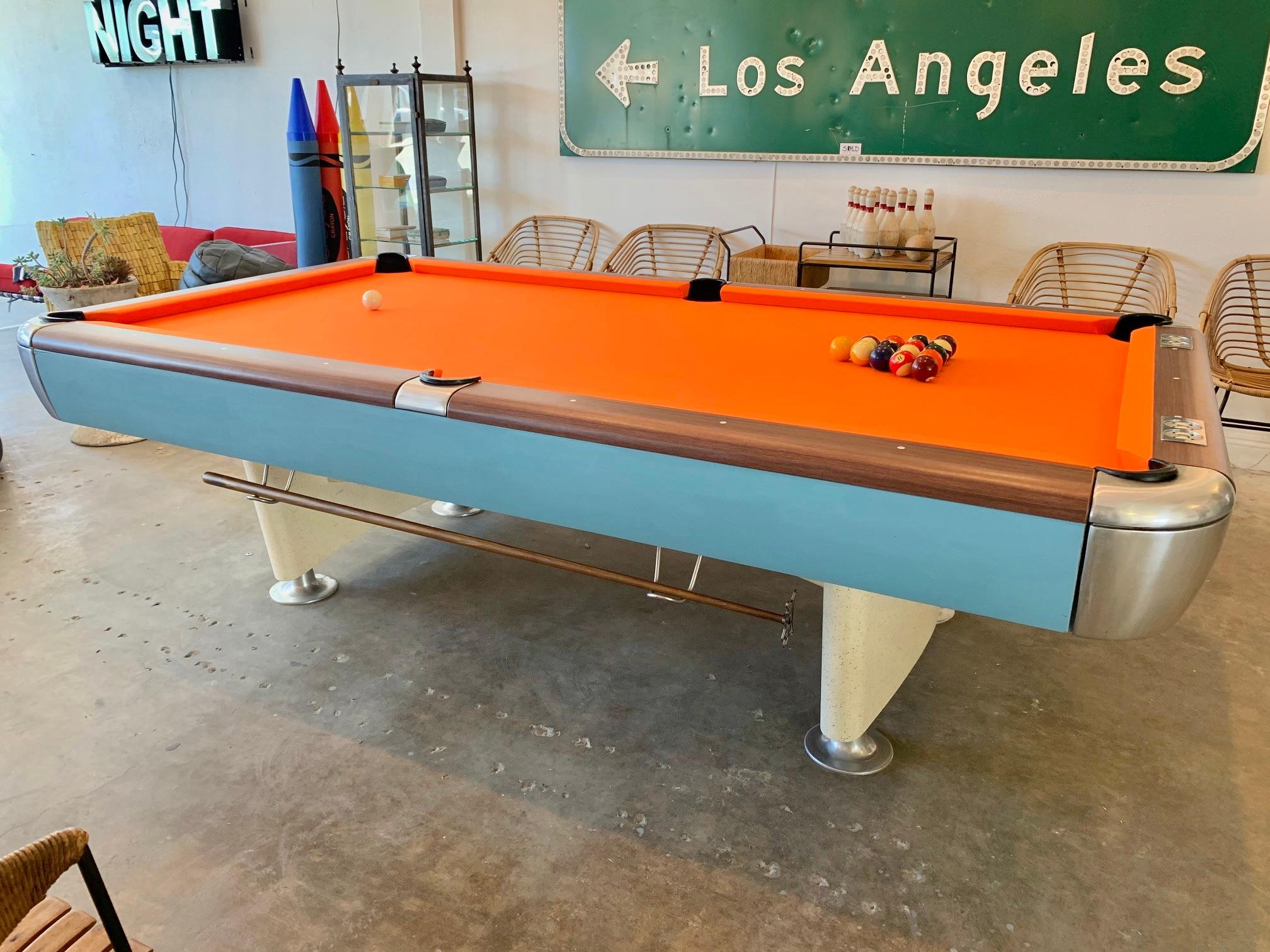 Saunier Wilhem Company vintage pool table from the 1970s. This company went out of business in the 1980s and their pool tables are hard to find. Just restored felt with Championship covering in Signal orange. Baby blue wood side panels with chrome