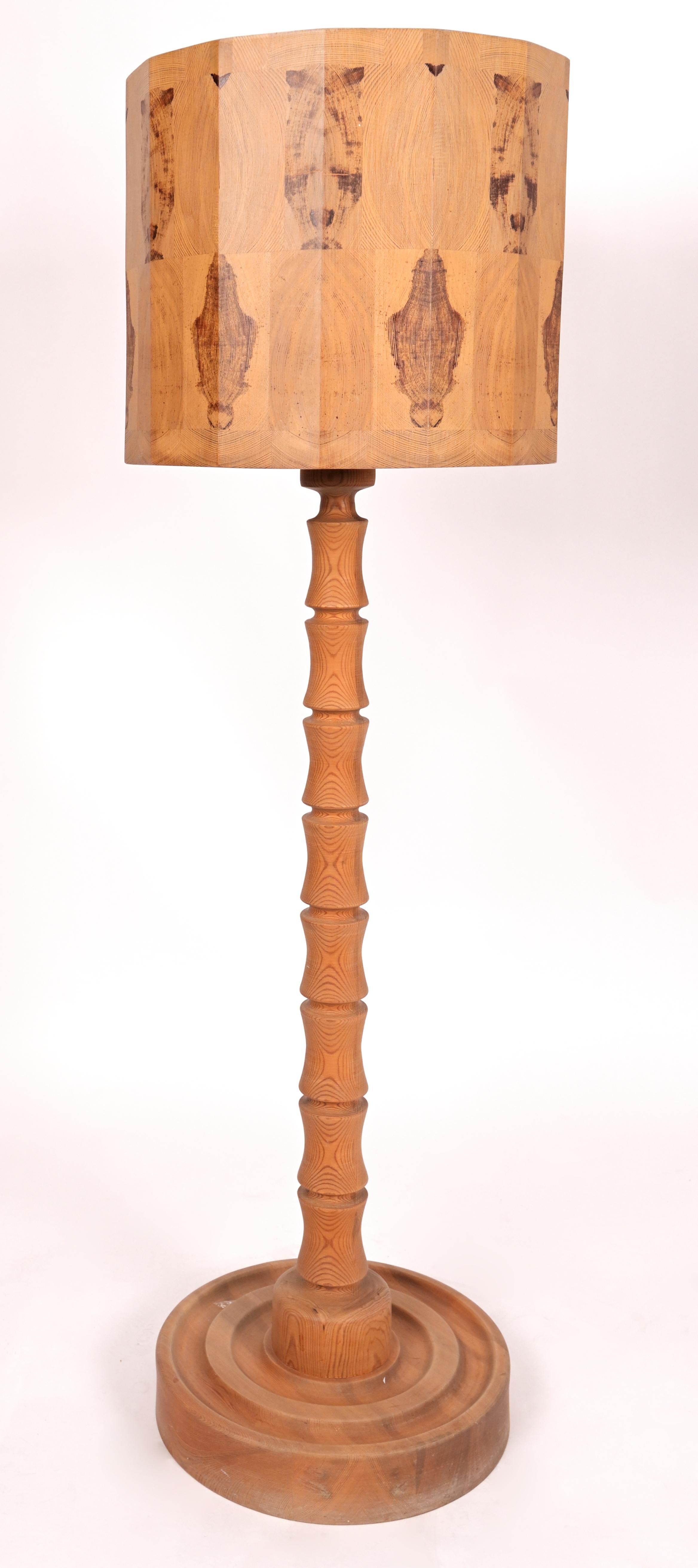 A pair of Intricate Hand Carved pine wood lamps with marbled ribbed stands and decorated shades. Each unique shade has 14 cross sections of veneer configured vase and oval shaped patterns. The lamps have fitted pine diffusers with round holes for