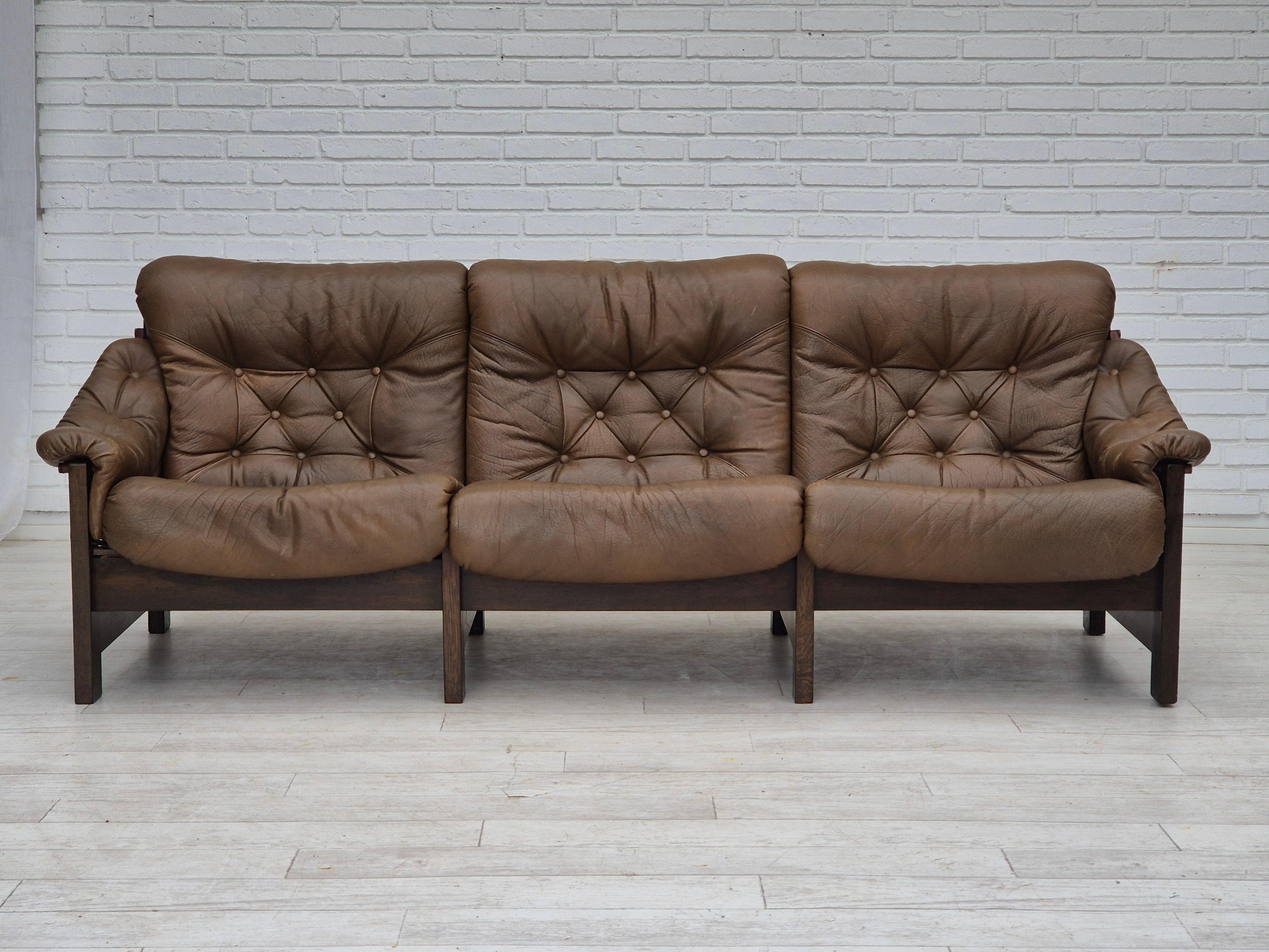 1970s, Scandinavian design. 3 seater sofa in safari style, original very good condition: no smells and no stains. Original brown leather, brown canvas, and oak wood construction. Leather straps with brass clasps. Manufactured by Danish or Swedish