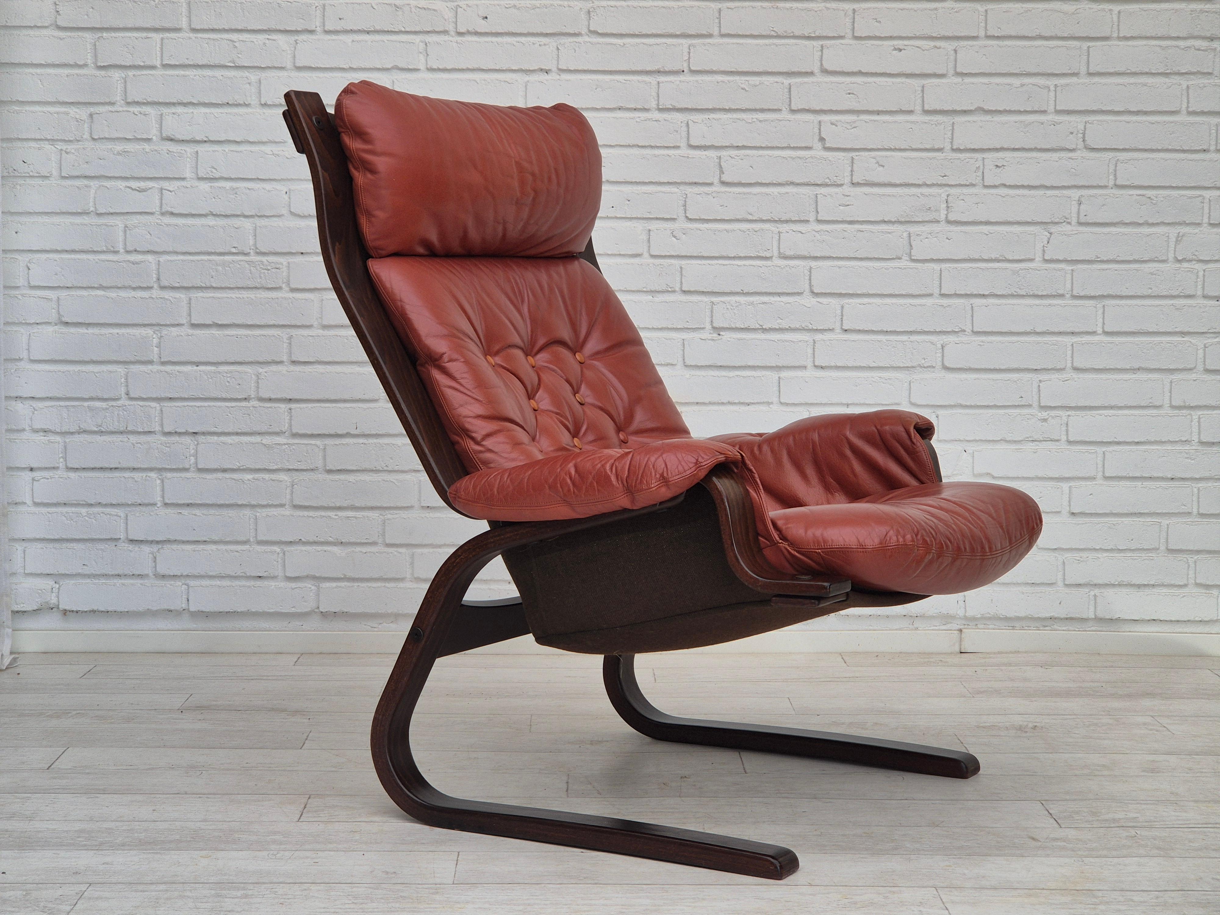 1970er Jahre, skandinavisches Design. Loungesessel in sehr gutem Originalzustand: keine Gerüche, keine Flecken, stabile Konstruktion. Braunes Leder, Leinwand, gebogenes Sperrholz. Hergestellt von einem norwegischen oder schwedischen Möbelhersteller.