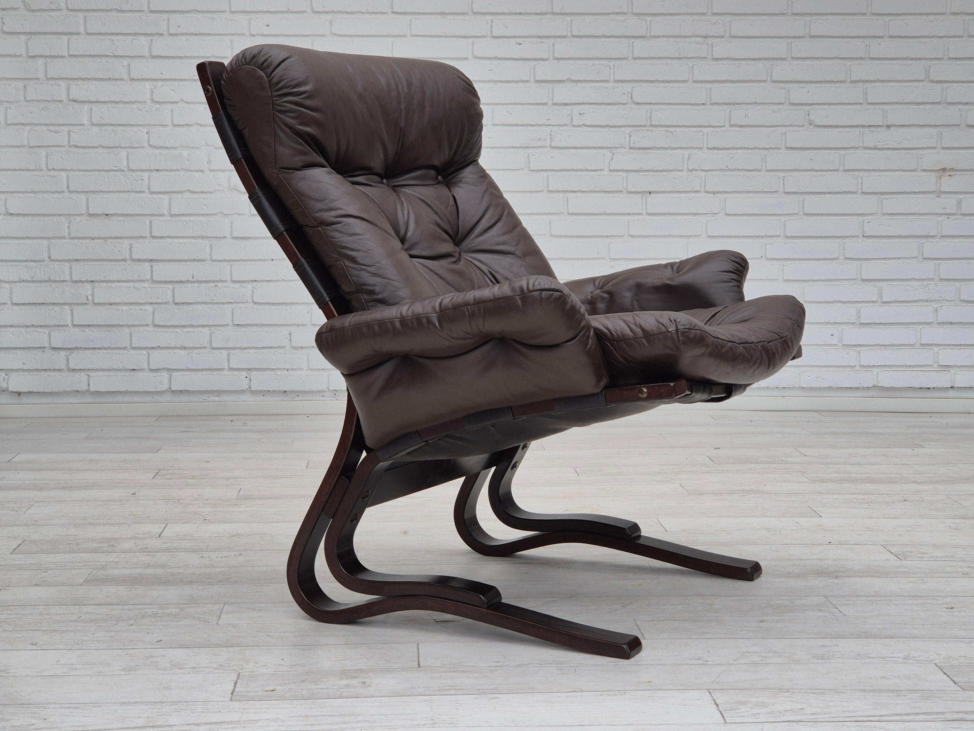 1970er Jahre, skandinavischer Loungesessel in sehr gutem Originalzustand: keine Gerüche, keine Flecken und stabile Konstruktion. Original braunes Möbelleder, gebogenes Holz. Hergestellt von einem norwegischen oder schwedischen Möbelhersteller in den