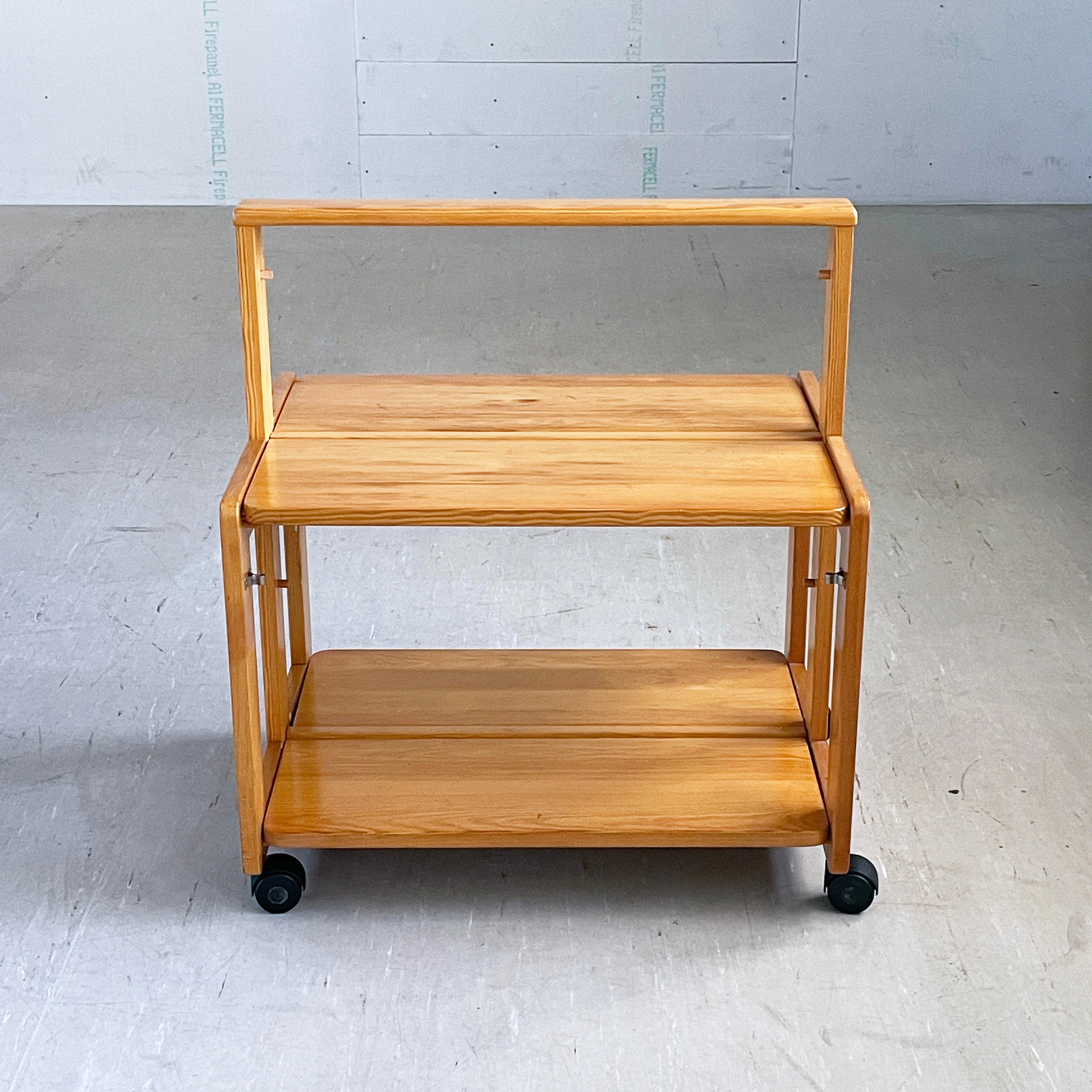 1970's Scandinavian pinewood folding serving trolley / drinks cart. Solid pinewood construction with folding tabletops. Perfect solution for storing away if space is limited with a folded depth of only 10 cm's.
In the style of Rainer Daumiller.
In