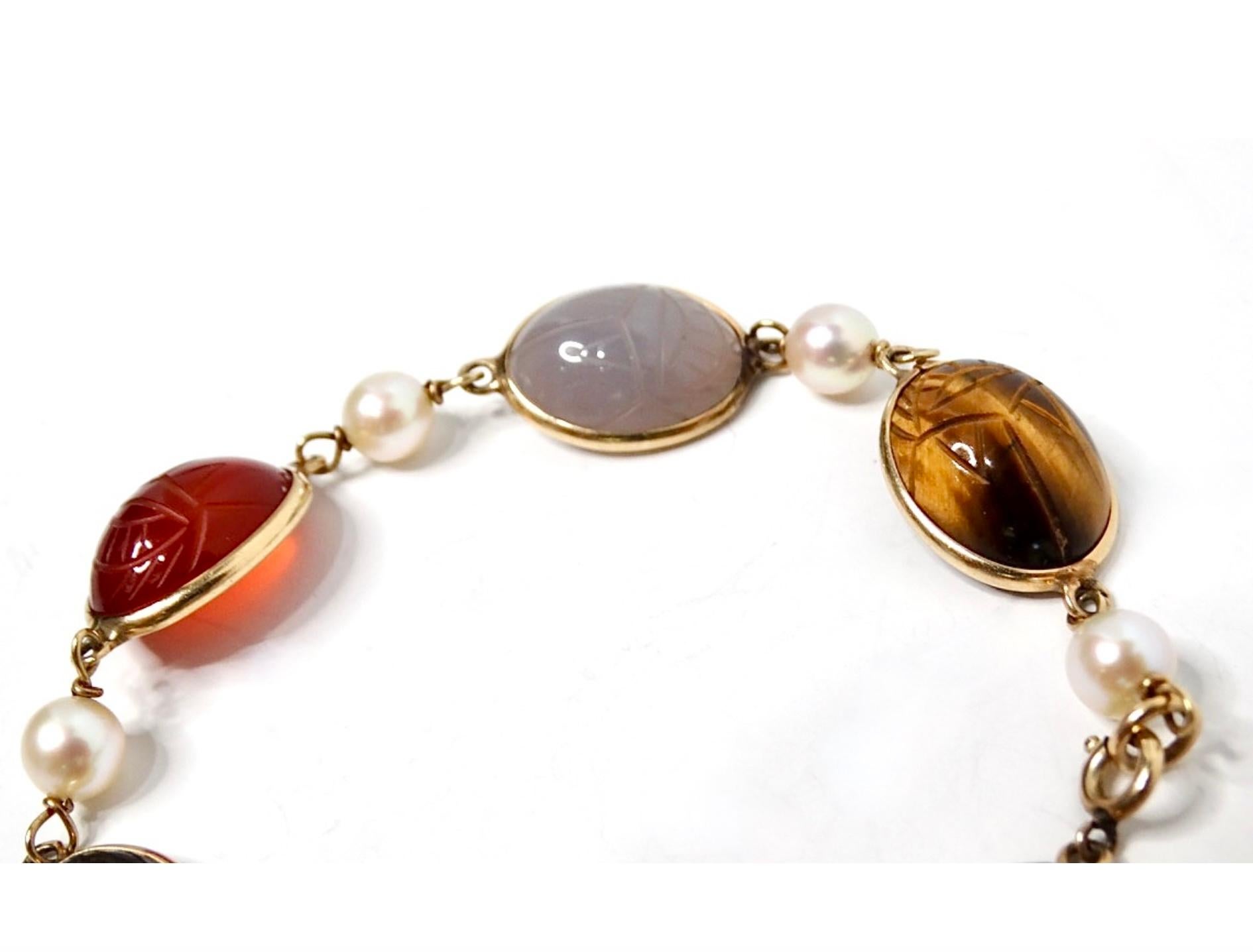 The 1970s Scarab Carved Multi-Gemstone & Pearl Bracelet is a true statement piece that captures the essence of vintage elegance. This exquisite bracelet features intricately carved scarab motifs set against vibrant multi-colored gemstones,