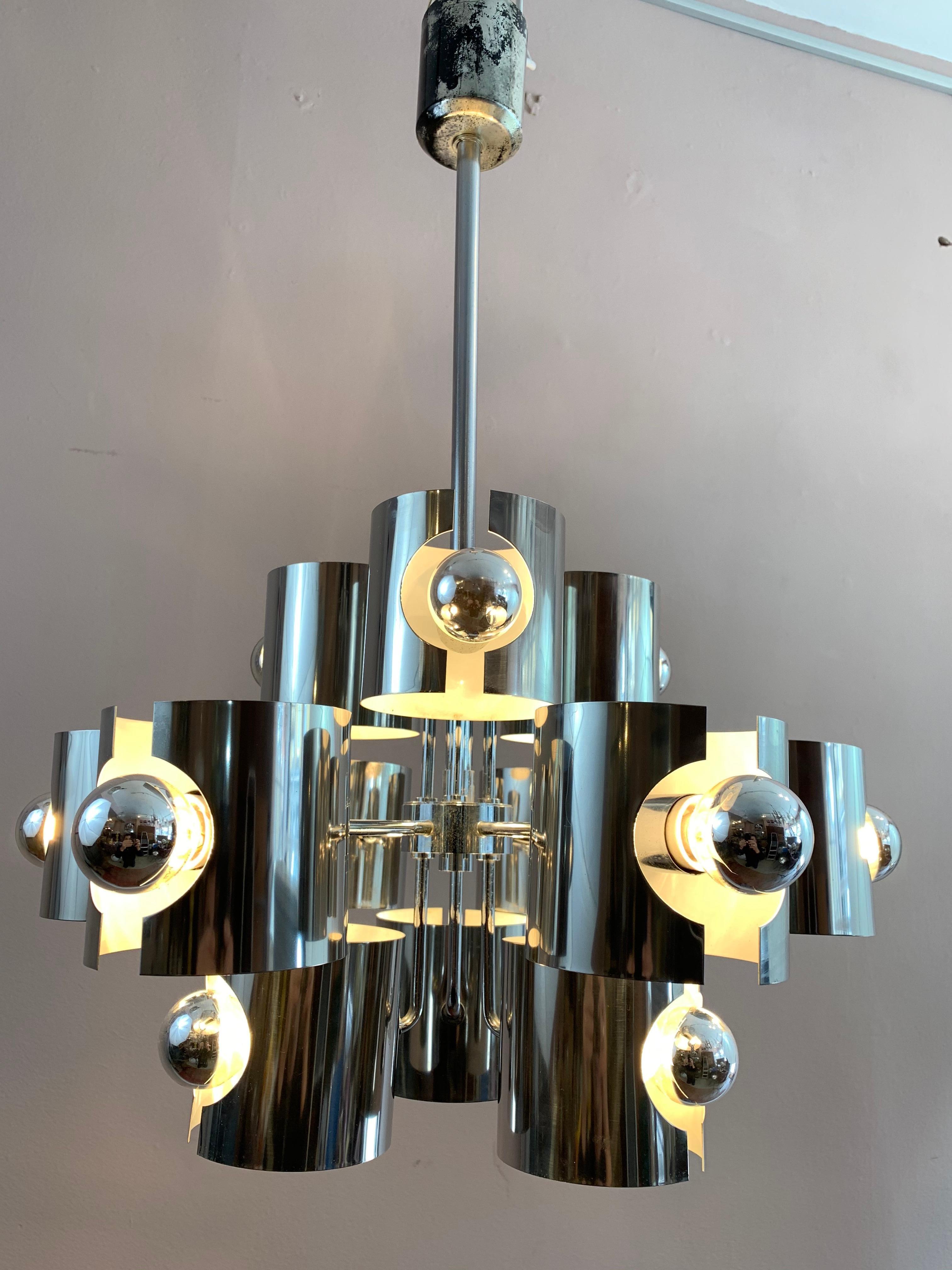 1970s Gaetano Sciolari abstract chrome ceiling hanging light. Each of the twelve sculptured shades, with lacquered white interiors, holds each bulb in place. The shades can either be turned vertically or horizontally as shown in the last few images.