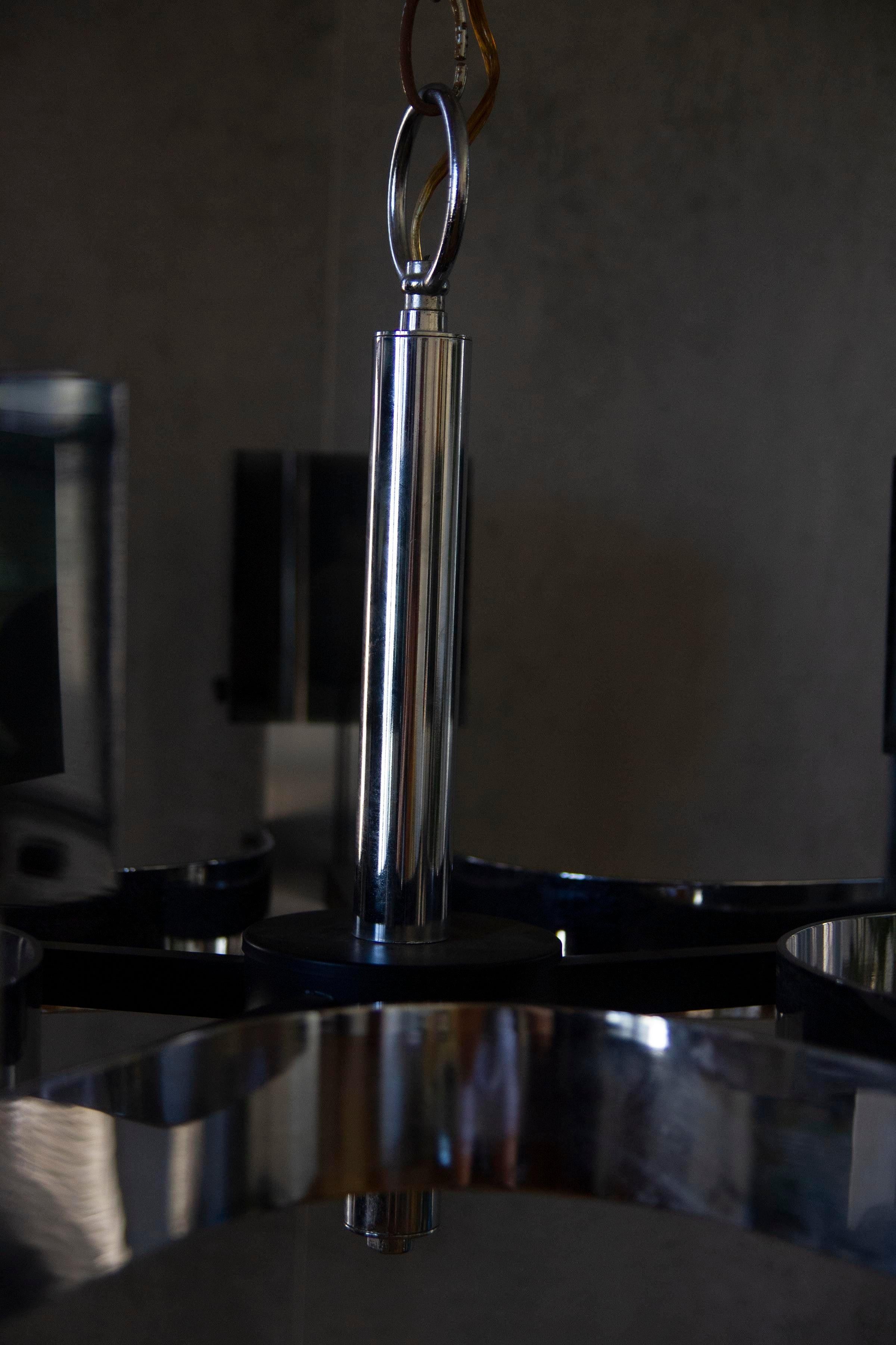 Designed by Gaetano Sciolari, this 1970's vintage Italian chandelier utilizes polished chromed steel in the light housing to receive the custom cast glass shades. This chandelier has lamps inside as above and can be lit 3 different ways.